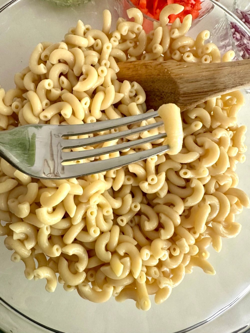 Cooked elbow macaroni cooling in a large glass bowl