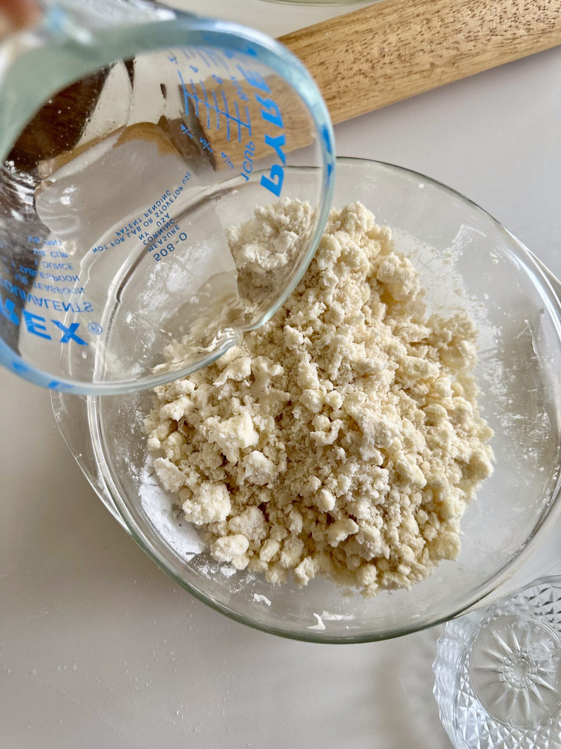 Ice water being added gradually to pie dough