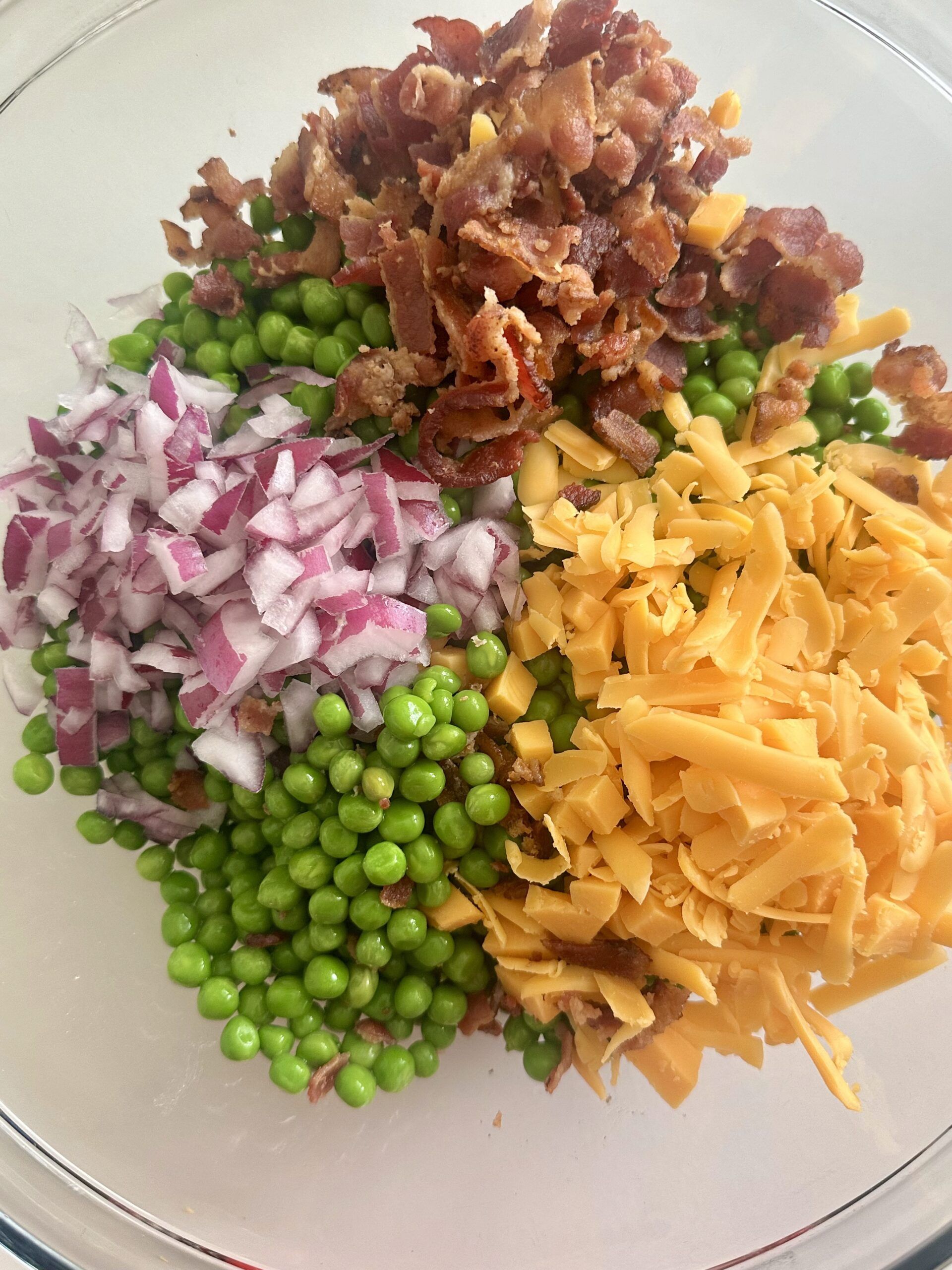 Green peas, red onion, and cheddar added to the dressing