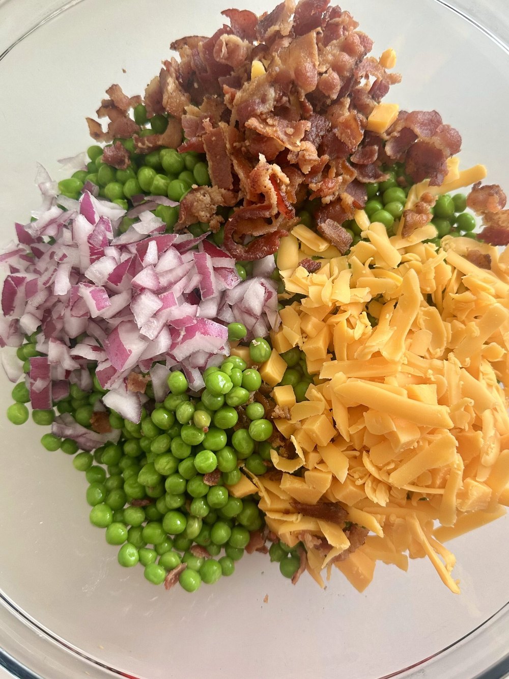 Green peas, red onion, and cheddar added to the dressing