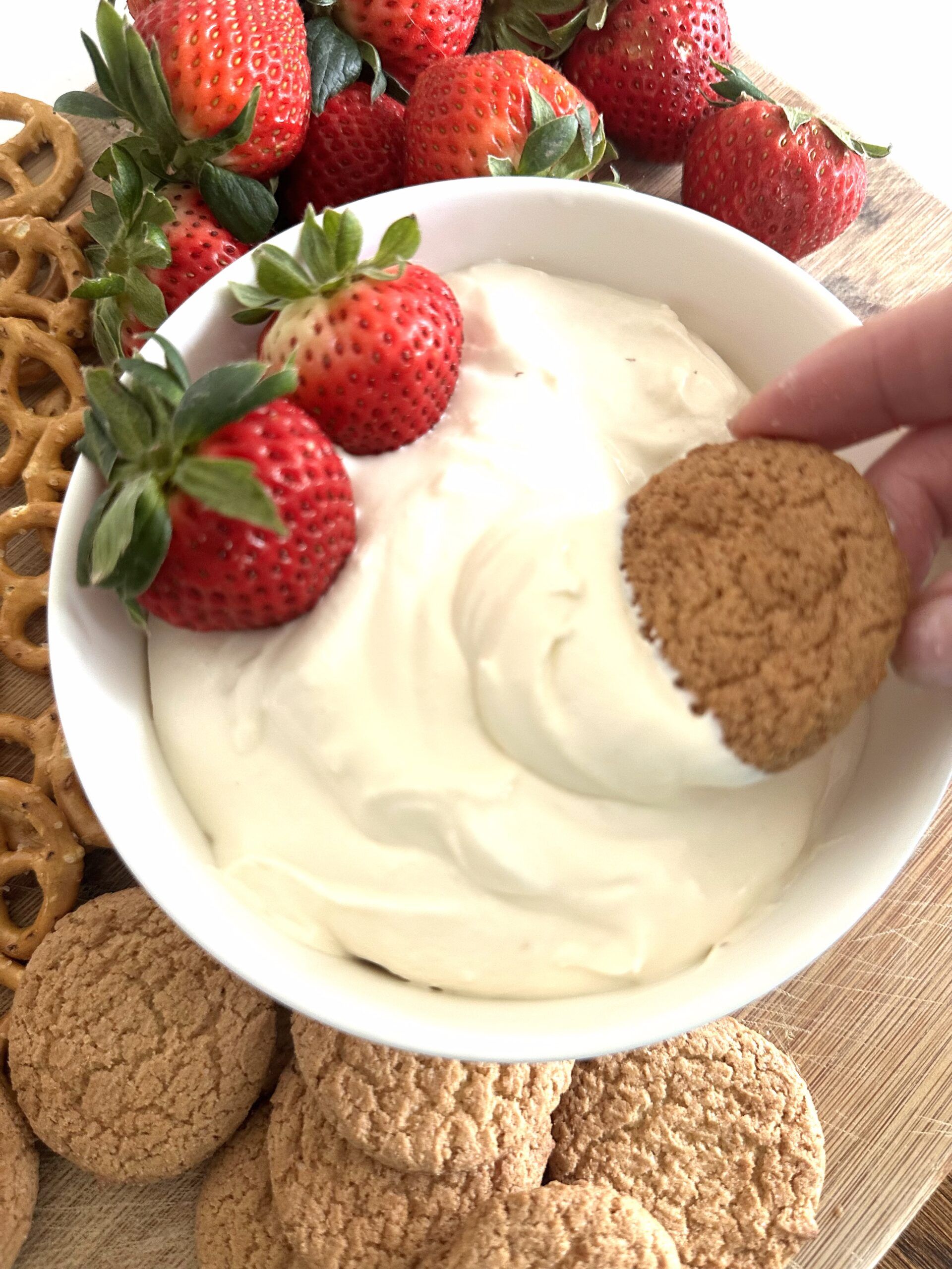 Creamy no-bake cheesecake dip served with strawberries, pretzels, and cookies