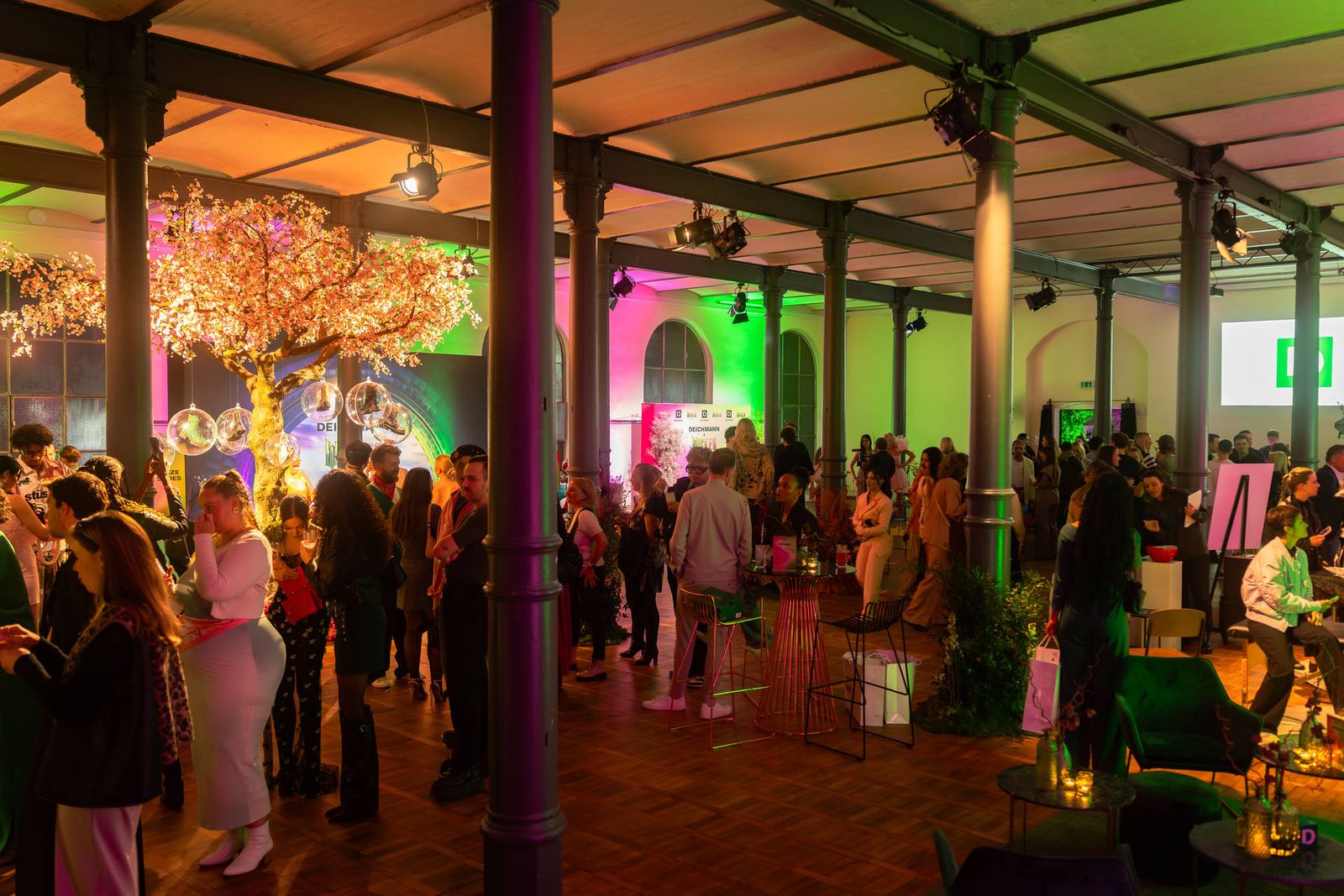 Gäste in farbig beleuchteter Eventlocation Berlin, Fotograf Silvio Pelegrin