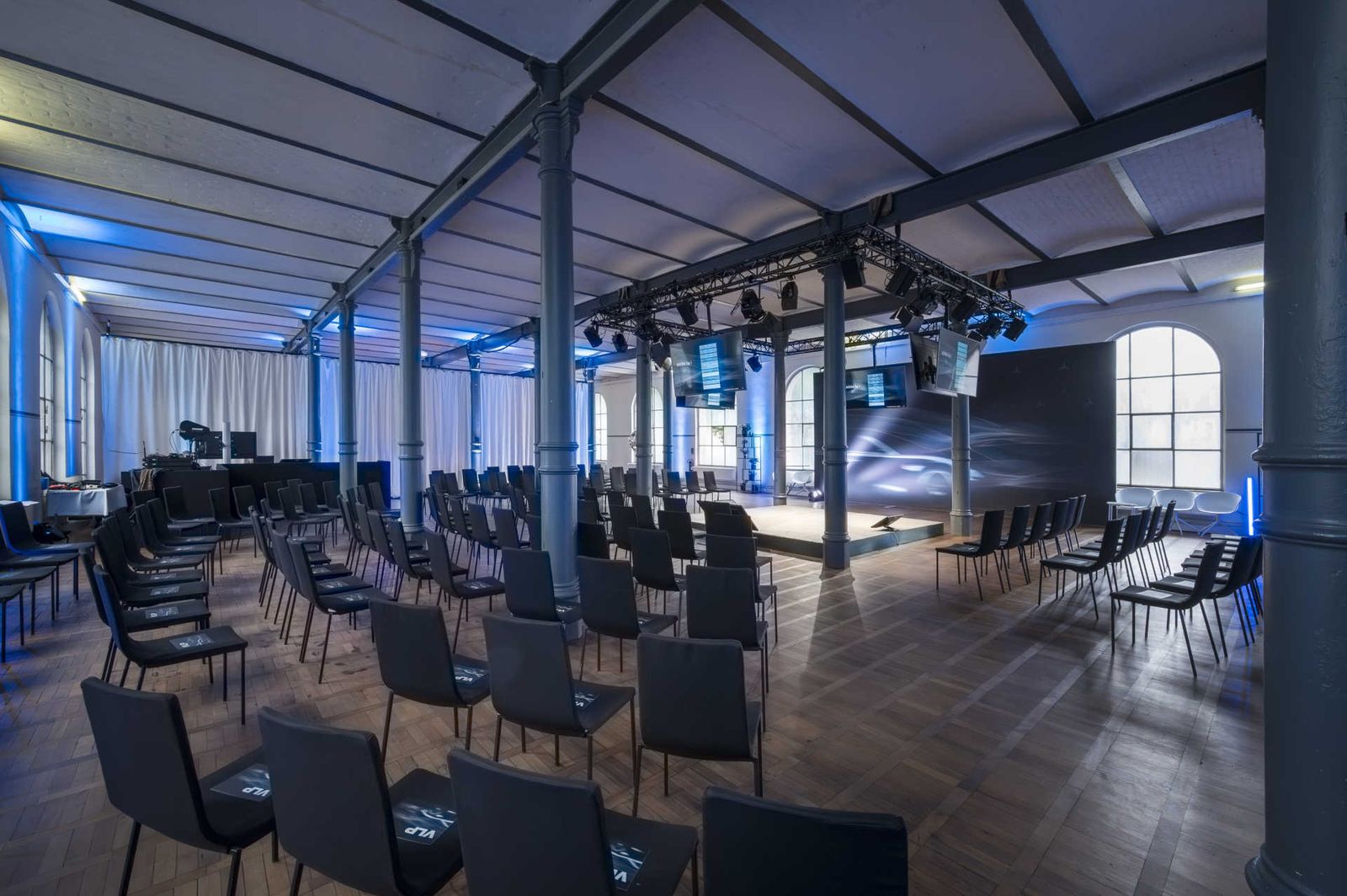 Großer Saal mit zentraler Bühne und Konferenzbestuhlung