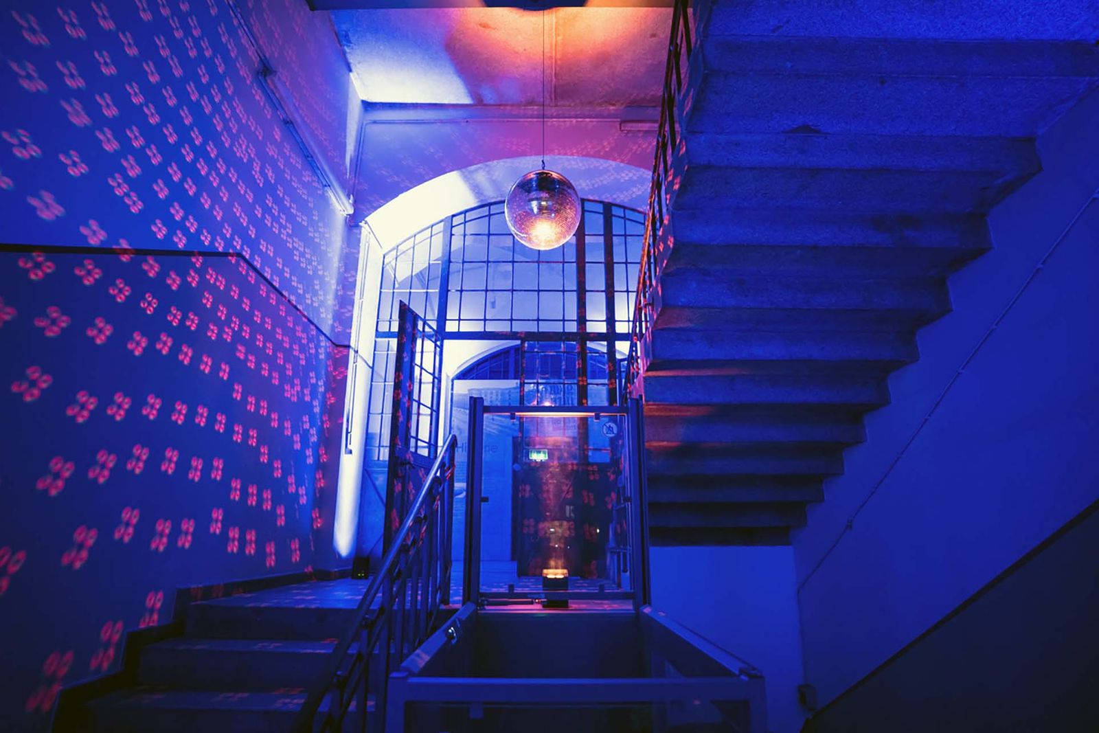 Eventmarketing Berlin – stimmungsvolle Abendveranstaltung mit blauem Lichtkonzept und Discokugel im Magazin in der Heeresbäckerei