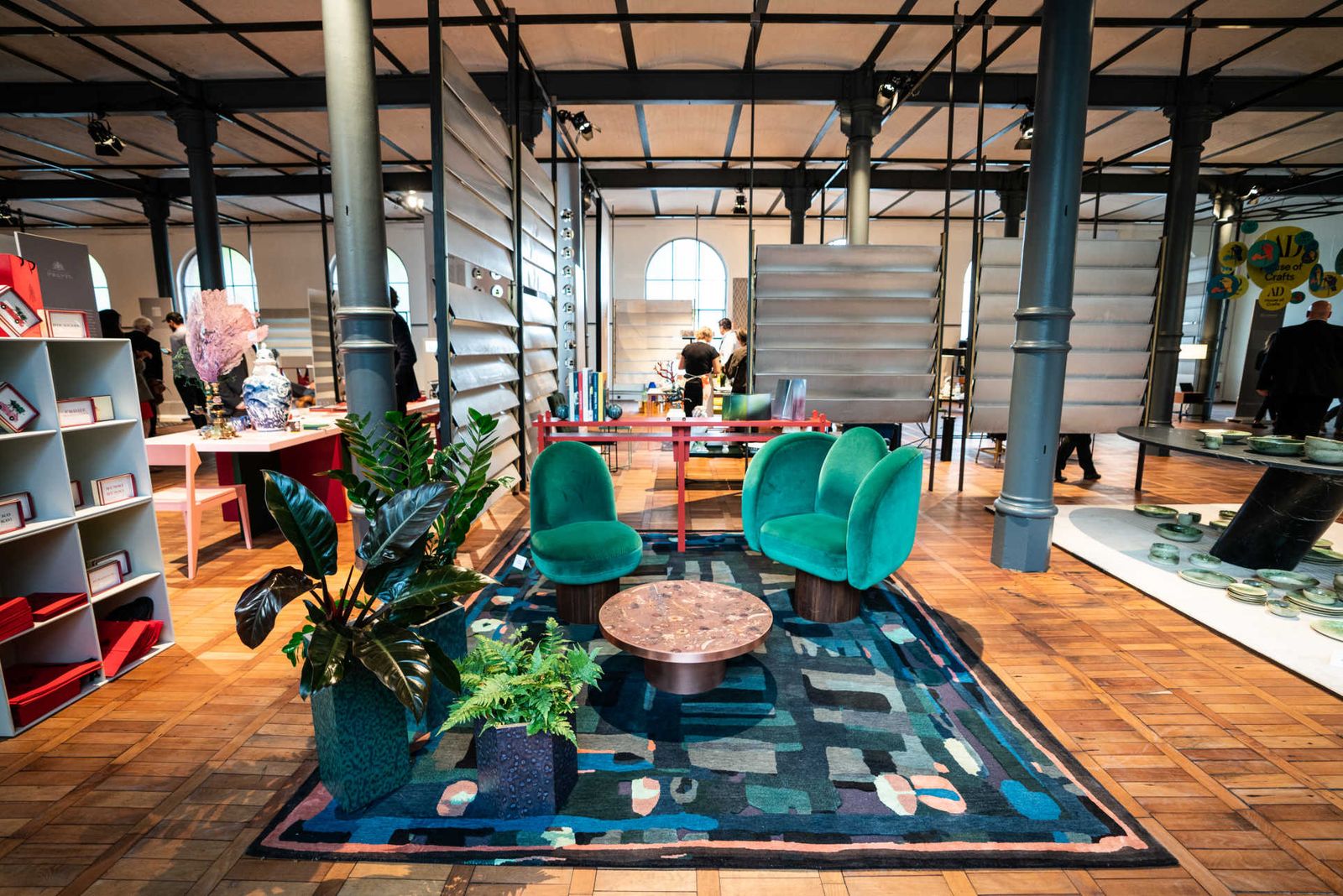 Section of a furniture fair with designer armchairs and jalousie room dividers.