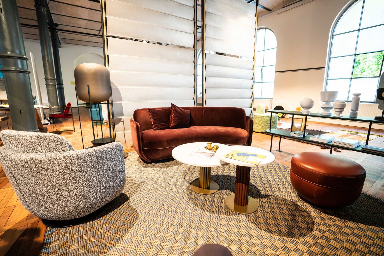 Section of a furniture fair with designer armchairs and jalousie room dividers.
