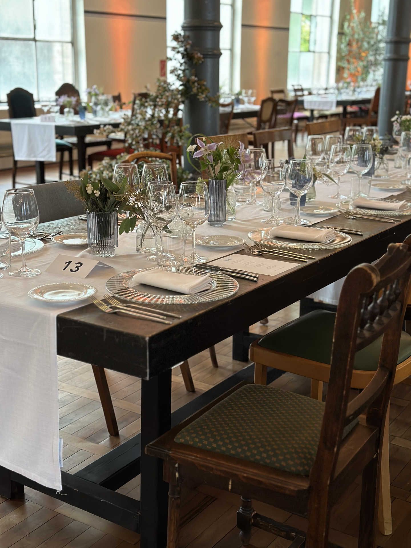 Festsaal mit langer gedeckter Tafel und weißem Tischläufer