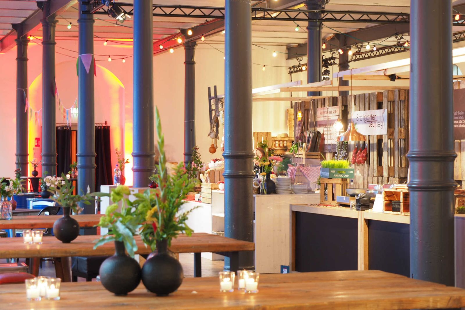 Saal mit Säulen und Foodstationen.
