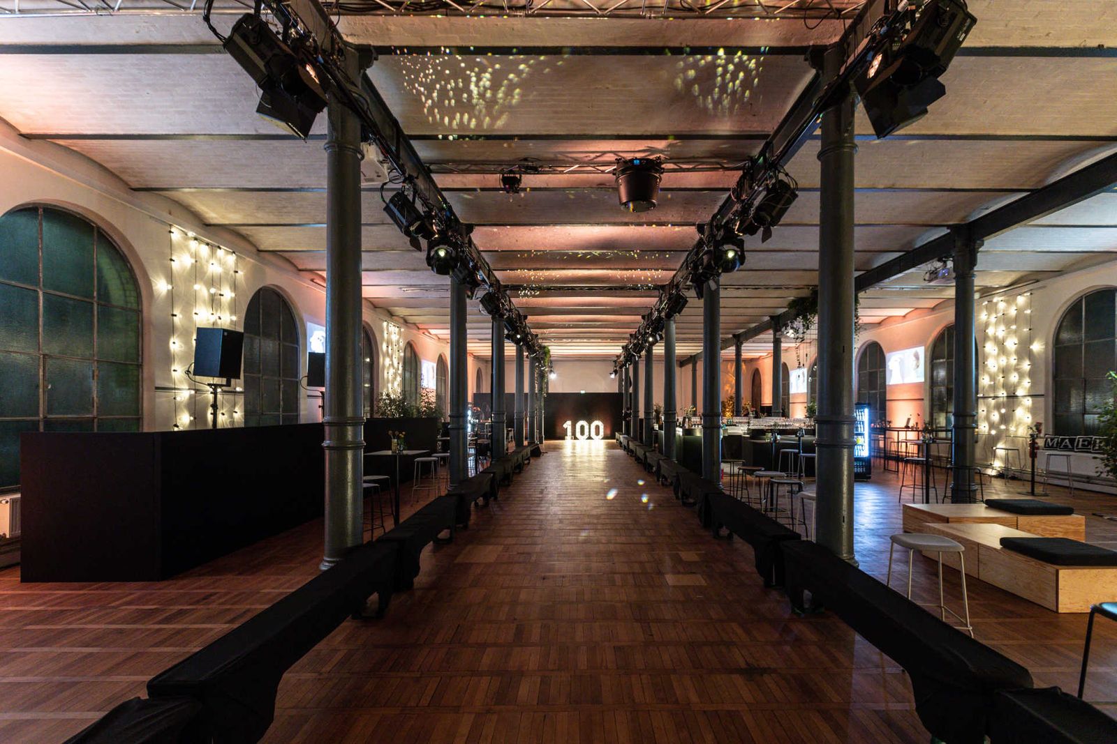 Long industrial hall with atmospheric lighting, full-length runway and illuminated signage