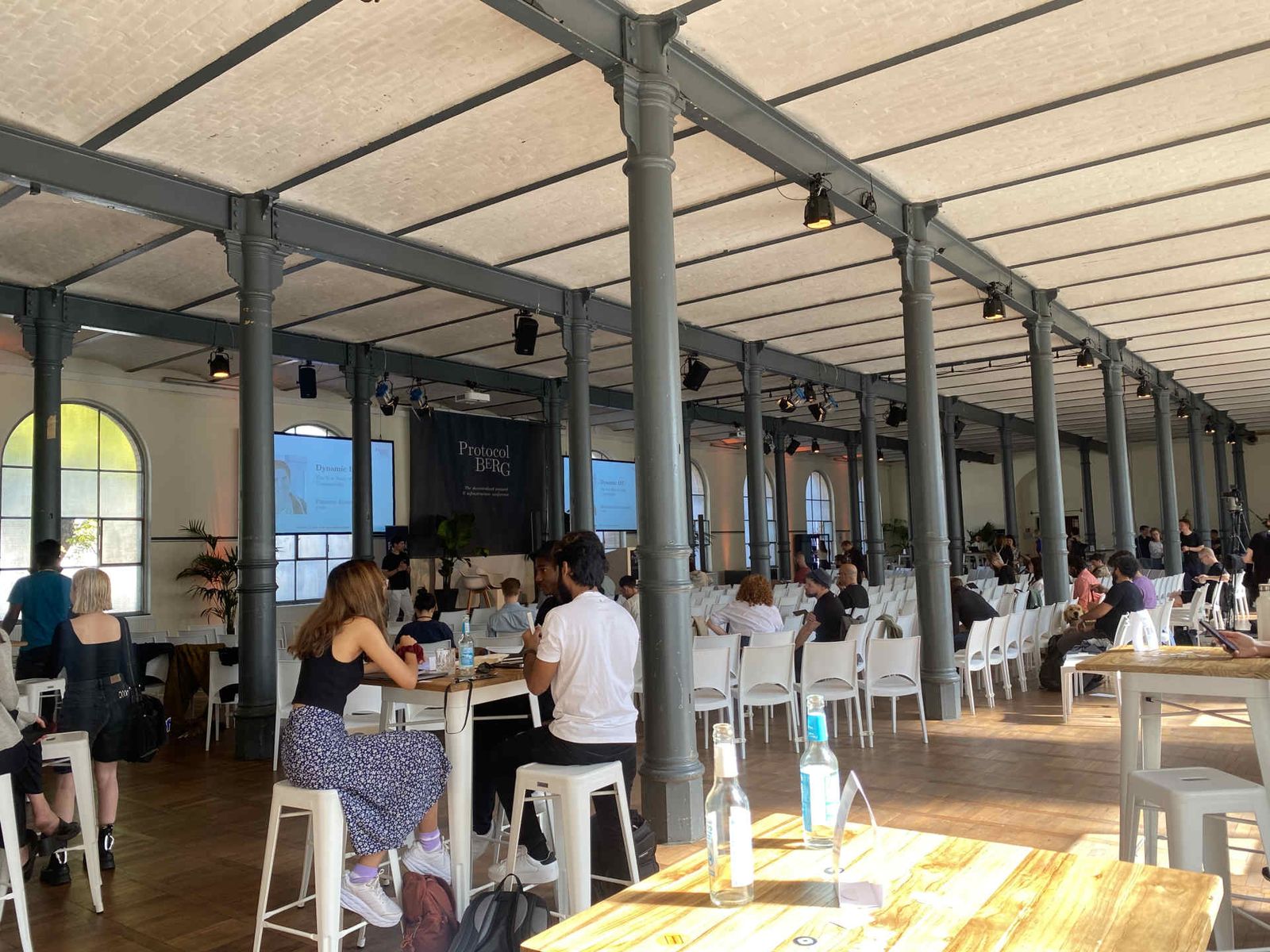 Eventsaal mit atmosphärischer Beleuchtung und Menschen während einer Veranstaltung.