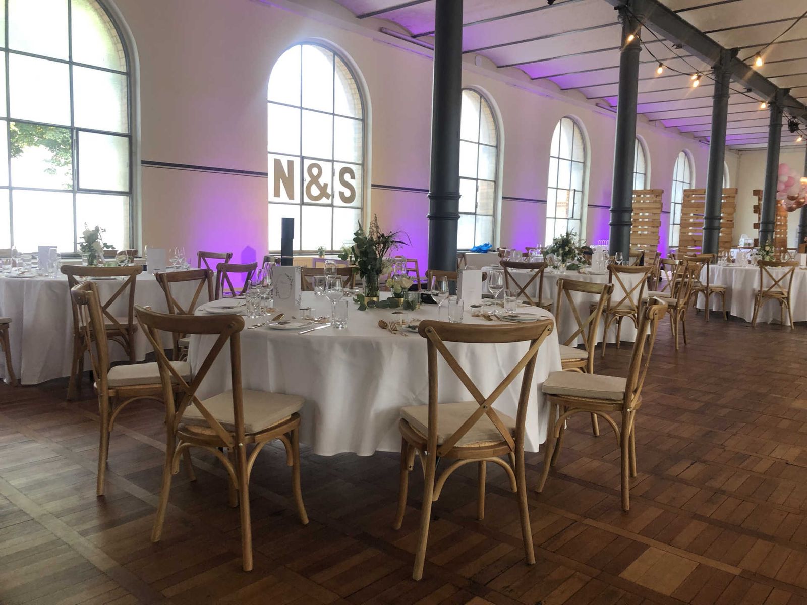 Festsaal mit runden Dinnertischen mit weißer Tischdecke.