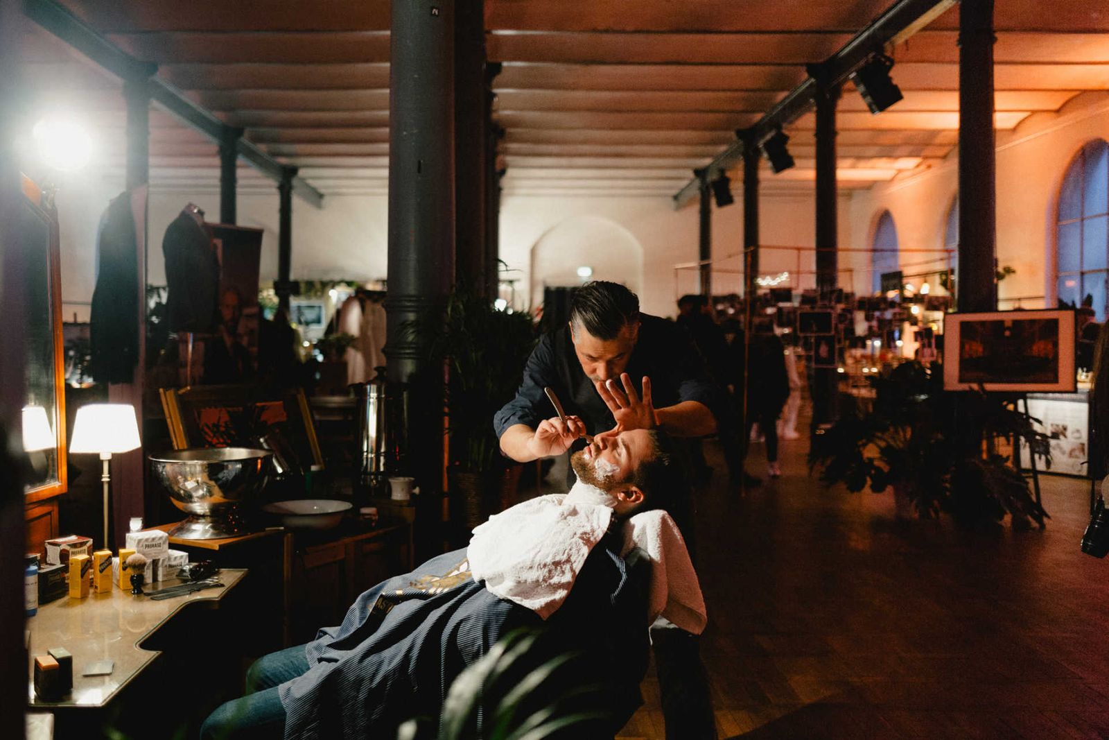 Barber setting with a man getting a shave at an event.