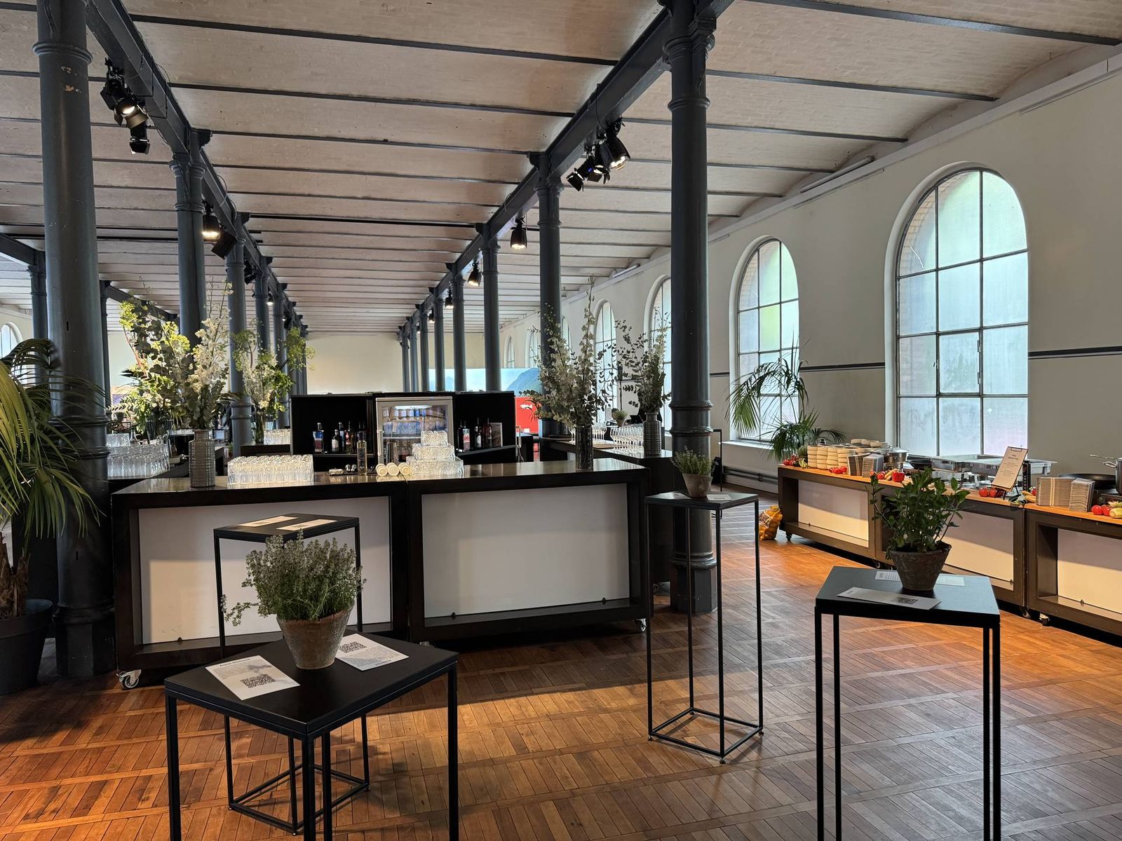 Firmenfeier Location Berlin: Saal mit Bar und Pflanzendeko