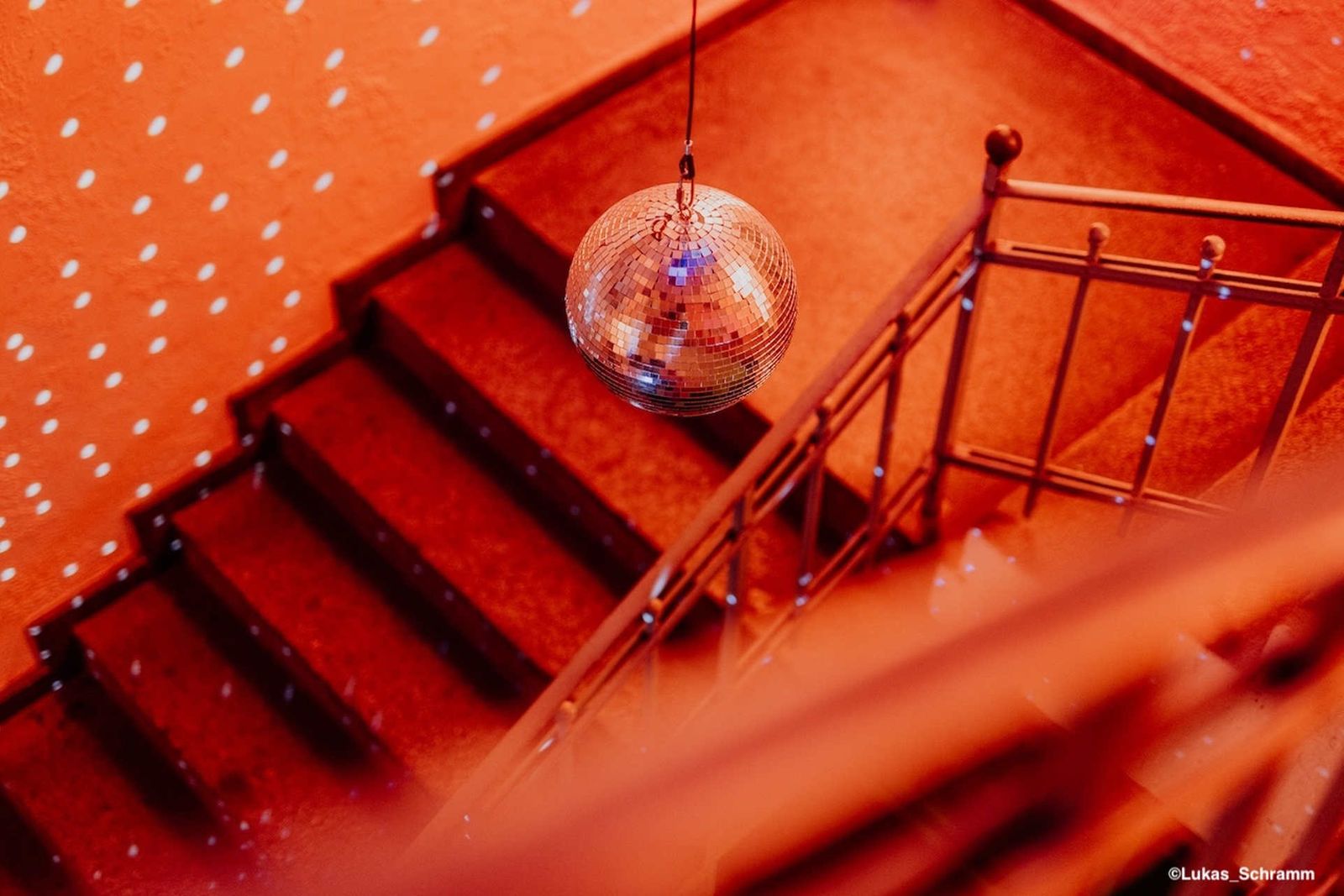 Weihnachtsfeier Location Berlin – Discokugel im rot beleuchteten Treppenhaus der Heeresbäckerei
