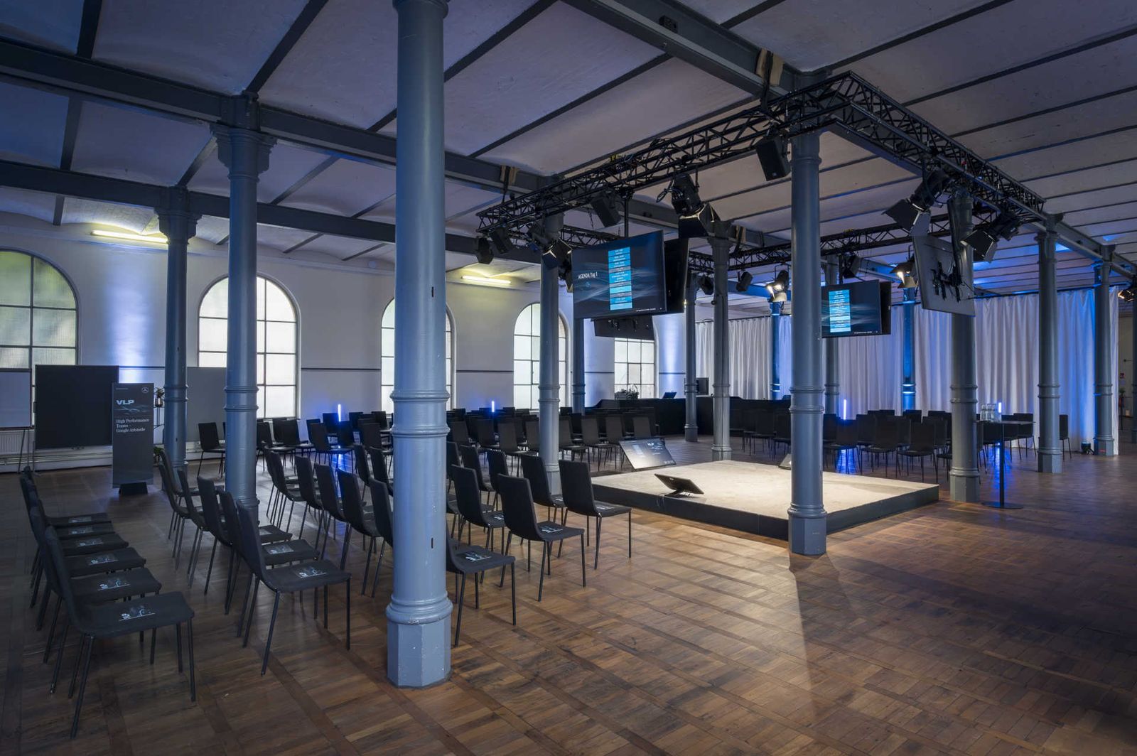 Großer Saal mit zentraler Bühne und U-förmiger Konferenzbestuhlung