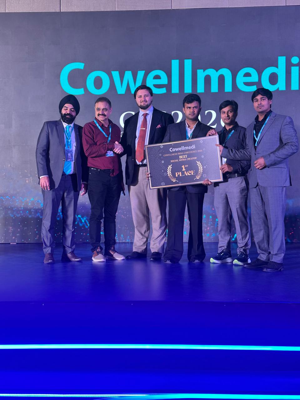 Dr Asad Frost standing with the award recipients on stage at COWELMEDI Conference 2026, celebrating first place in Best Social Media Creator.