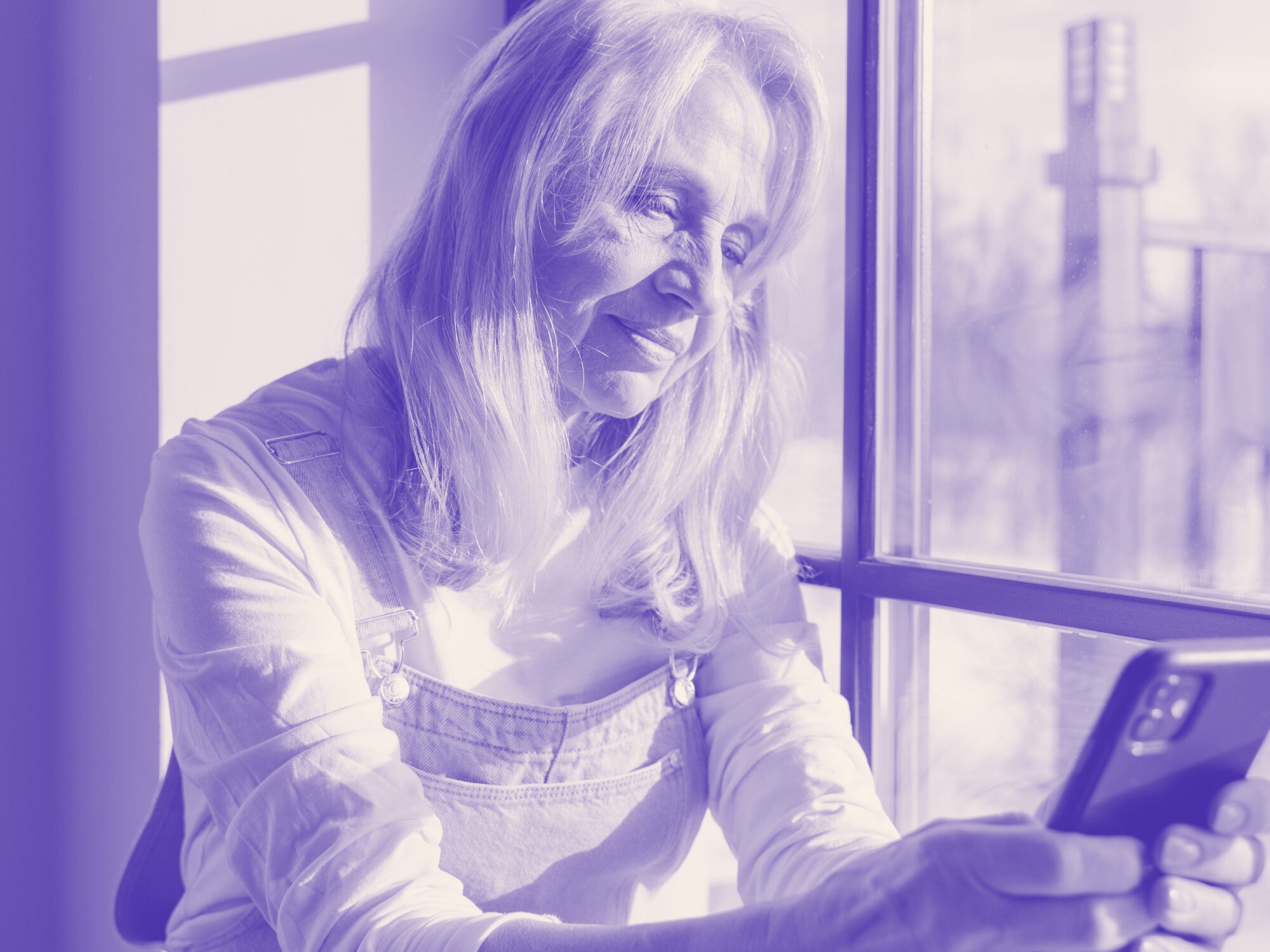 Woman reviewing smart phone screen at home
