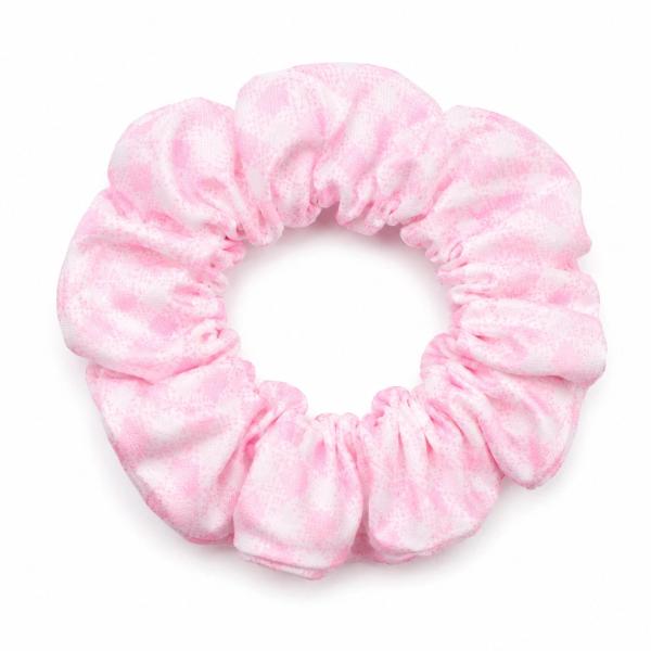 A light pink fabric scrunchie with a white speckled pattern and subtle sheen, photographed flat on a white background.