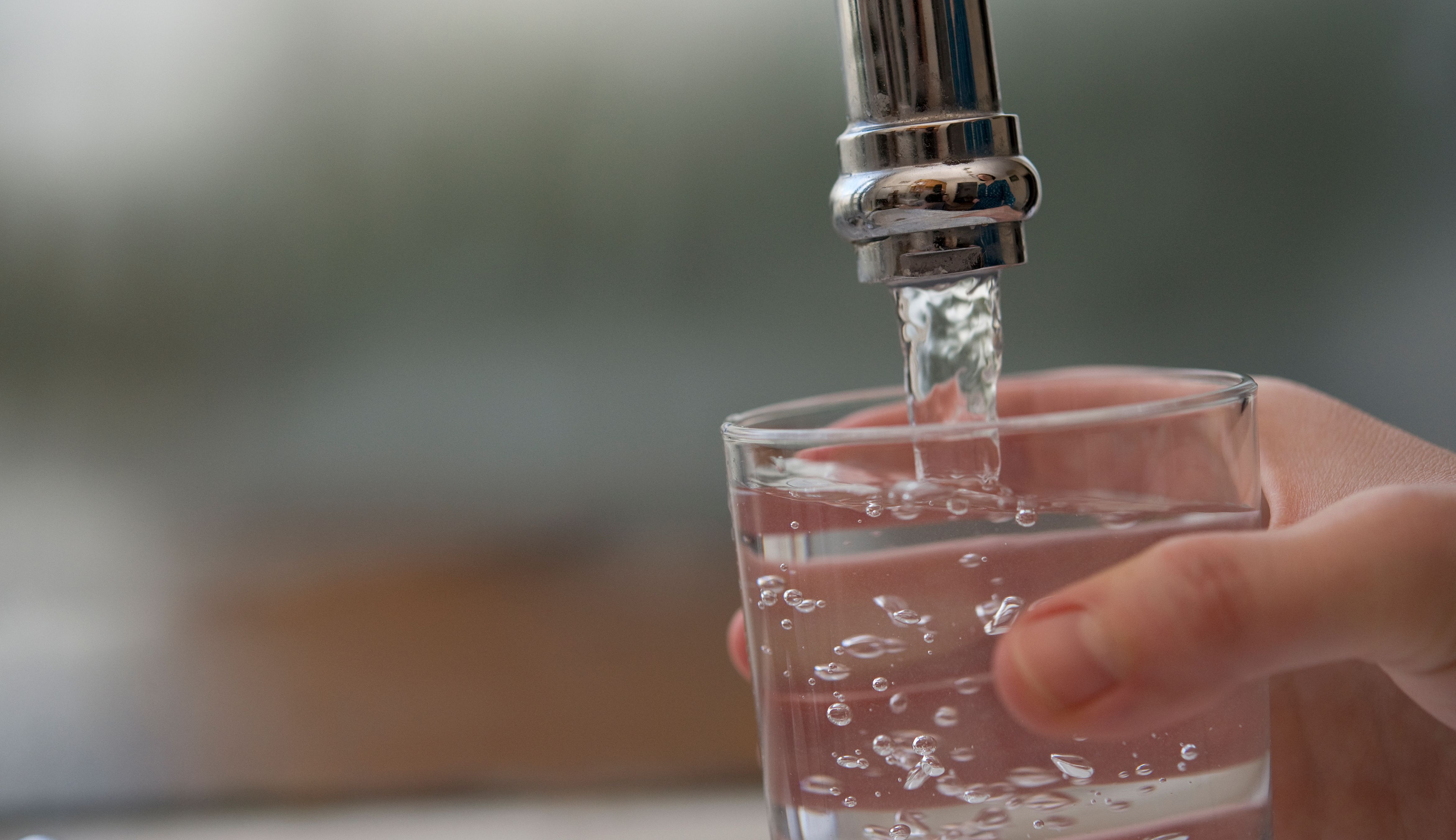 Decorative image of a glass of water being poured from a tap