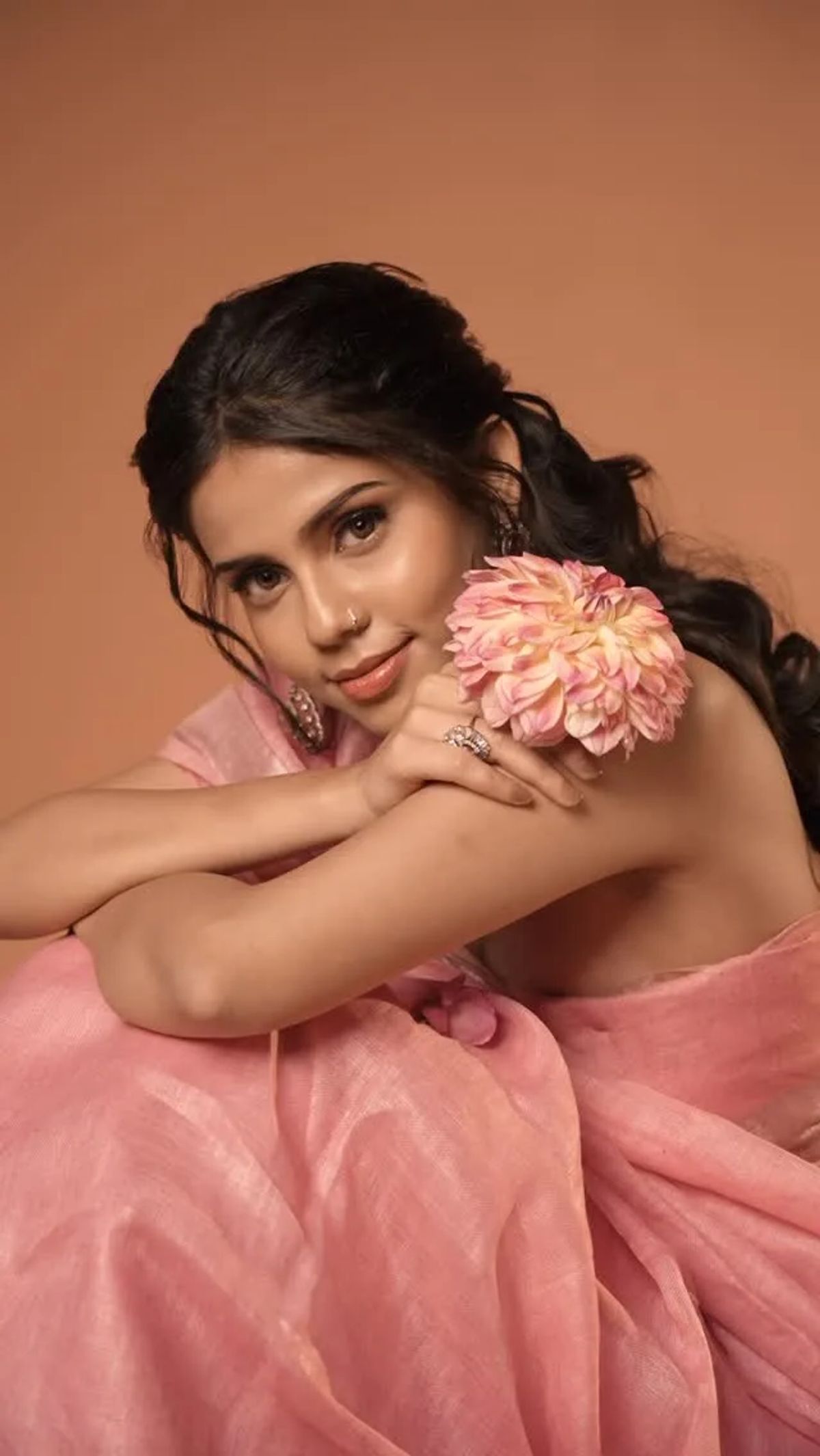 Soft pink editorial portrait holding a blush dahlia