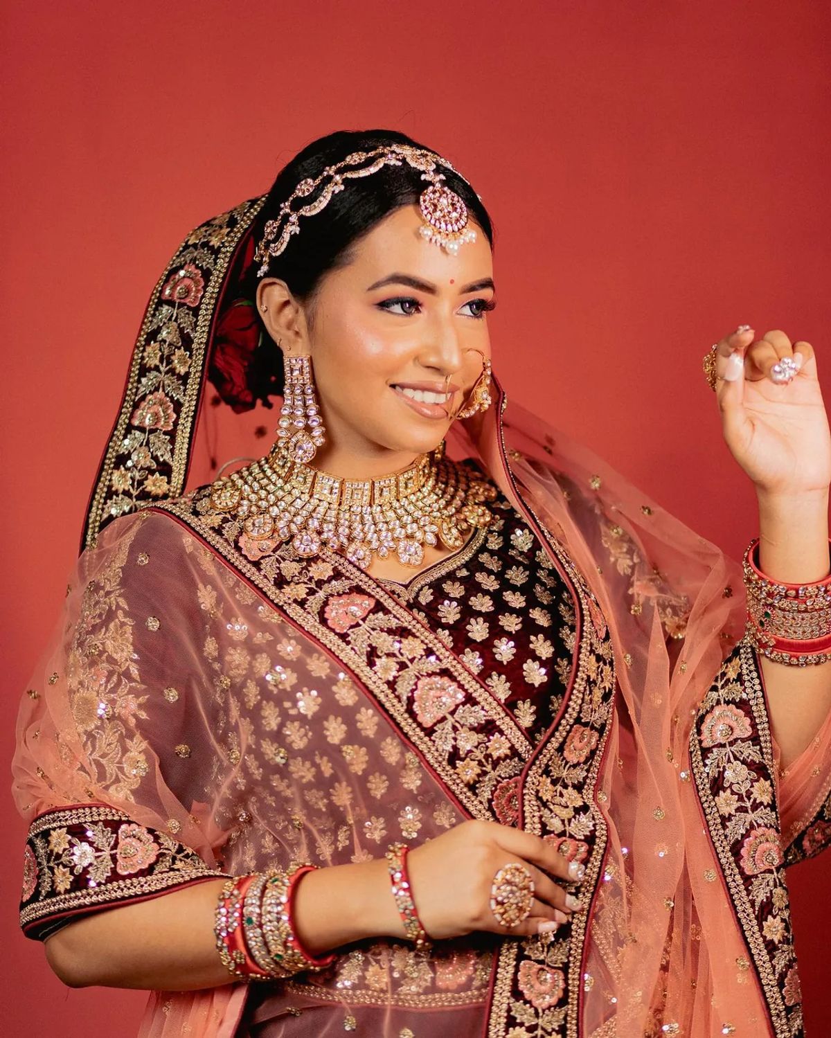 Bride in a maroon-and-gold zardosi blouse with a peach embroidered dupatta