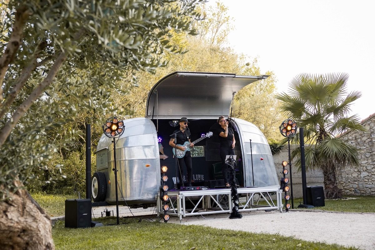 Duo Love & Live en concert de mariage avec guitare et chant devant leur caravane Airstream.