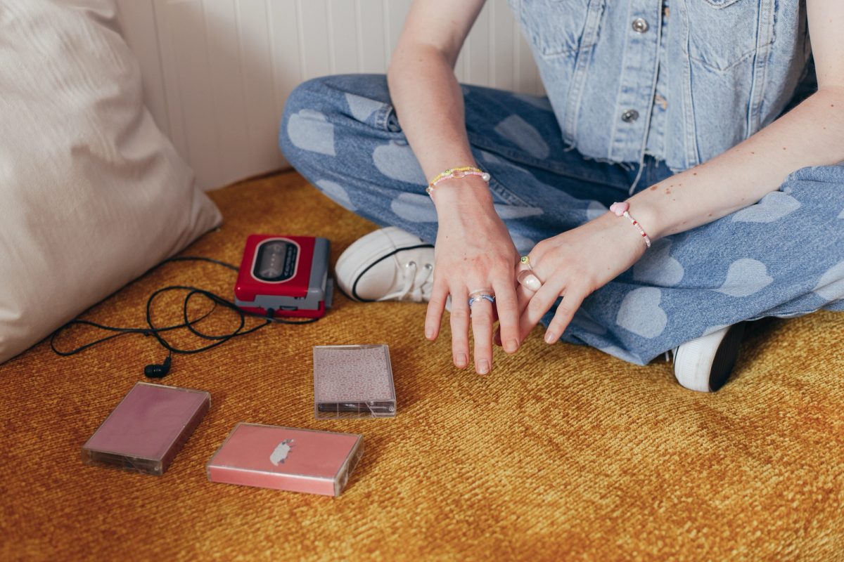 Ado nostalgique des années 90 écoutant de la musique avec un walkman et des cassettes audio, plongé dans l’ambiance rétro de la décennie