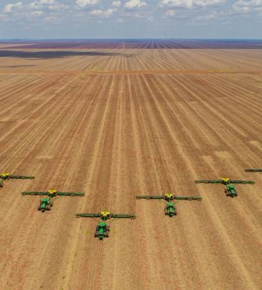Aerial image, number of machines in arrow motion, front of tractors that prepare the land to sow in the field.