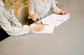2 women reading through business operations documents