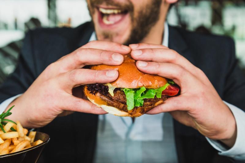 a man eating a burger from fast food company