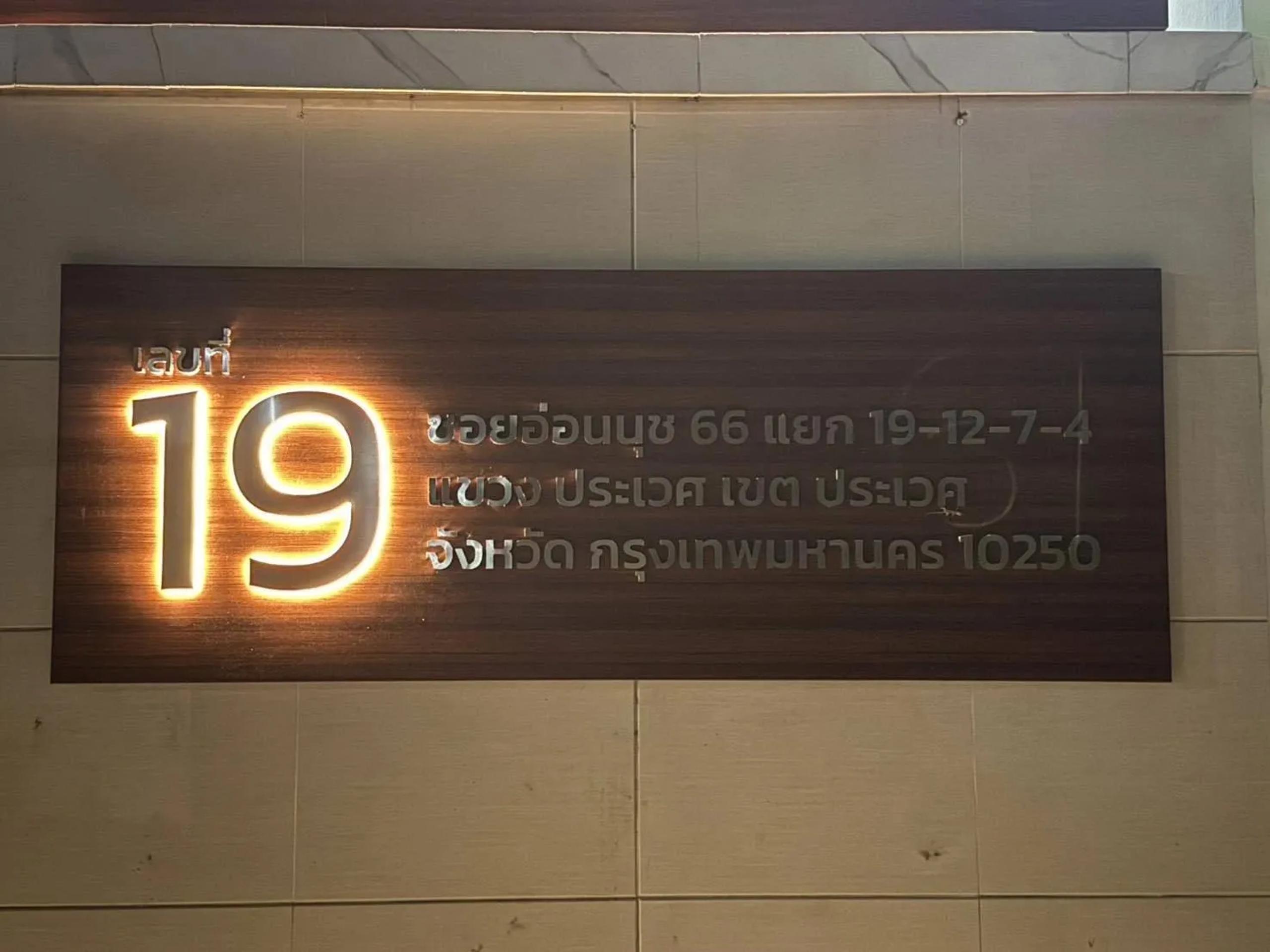 ป้ายเลขที่ 19 ไฟส่องหลังพร้อมข้อความที่อยู่ ติดผนังอาคาร | Backlit house number sign No. 19 with address text on a building wall