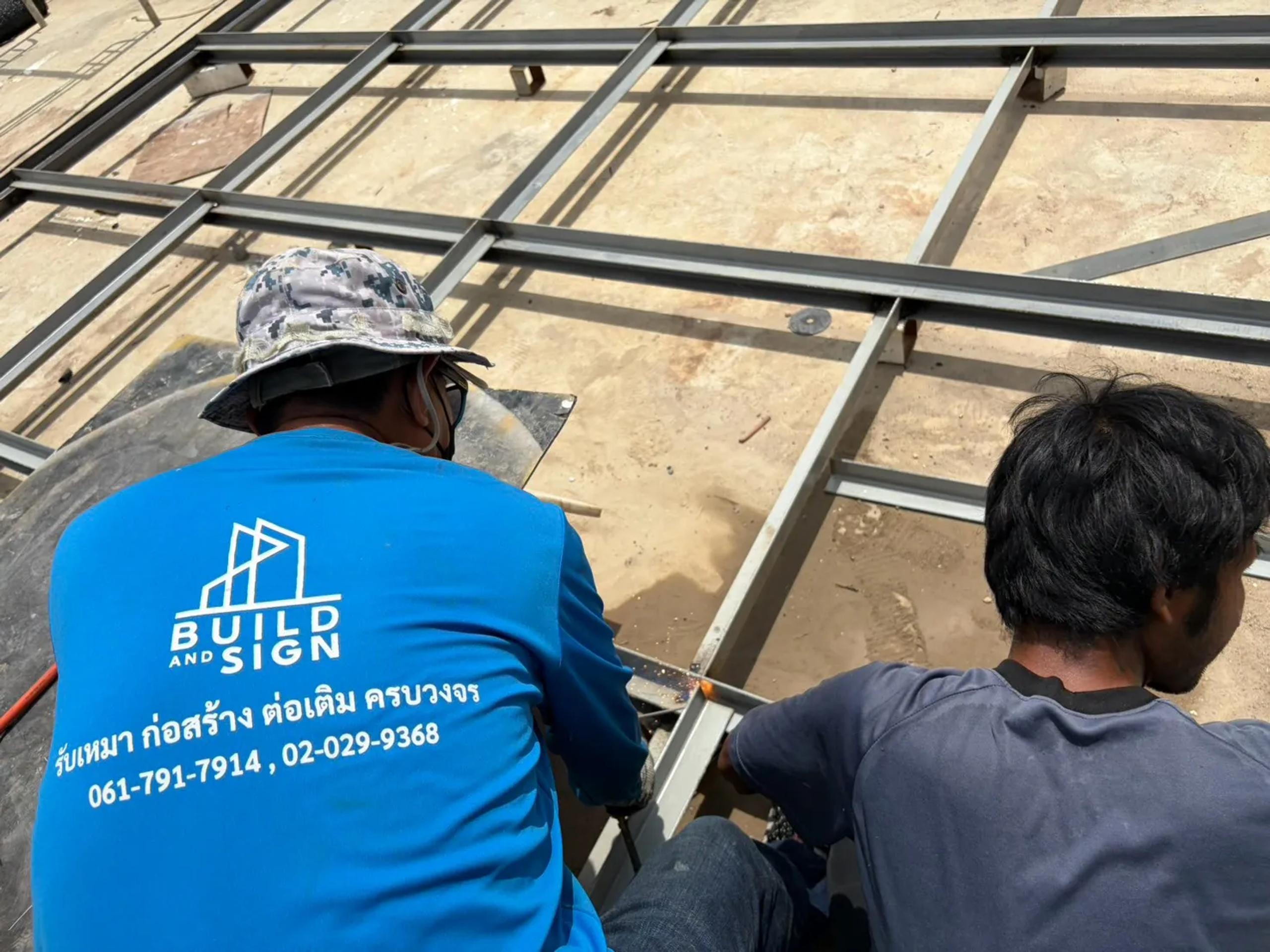 ช่างเชื่อมโครงเหล็กกล่องของหน้าป้ายบิลบอร์ดบนดาดฟ้าอาคาร | Technicians welding the steel box frame of a billboard face on a rooftop - Buildandsign