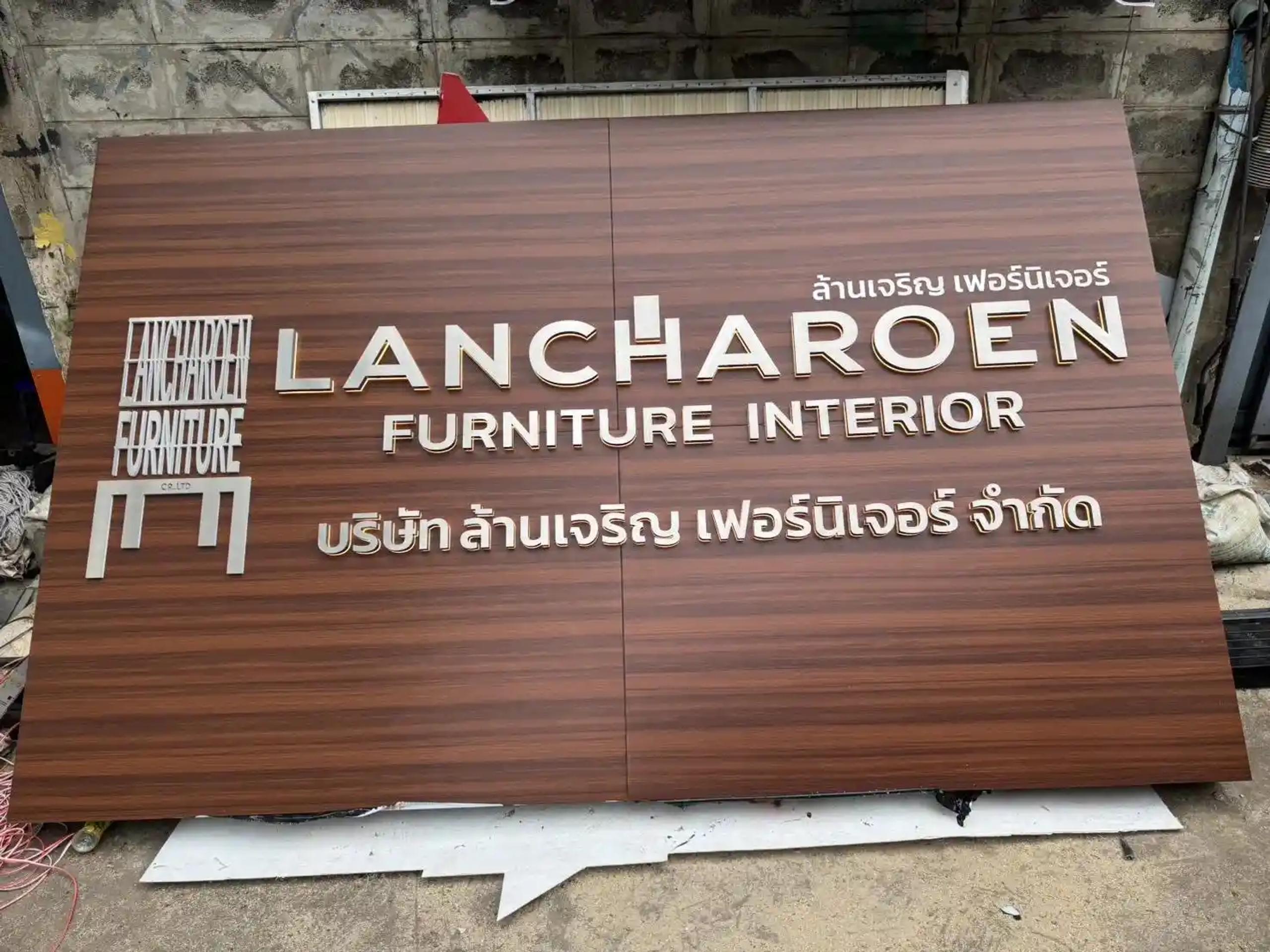 ป้ายชื่อบริษัท LANCHAROEN FURNITURE INTERIOR ลายไม้ก่อนติดตั้ง | Wood-grain company name sign for LANCHAROEN FURNITURE INTERIOR before installation