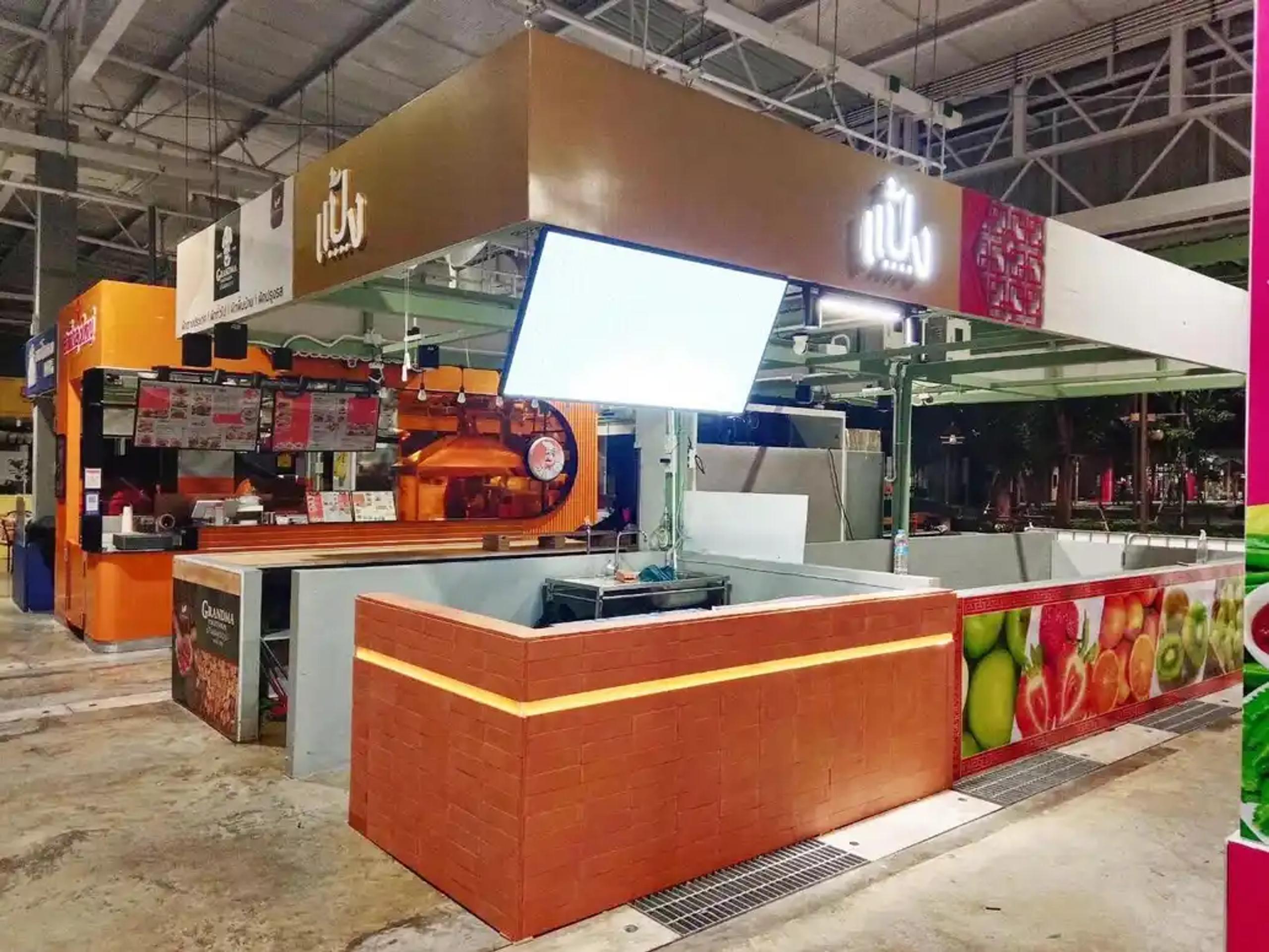 ป้ายไฟ LED และจอดิจิทัลติดตั้งที่บูธอาหารสีส้มภายในศูนย์การค้า | LED sign and digital screen installed at an orange food booth inside a shopping center