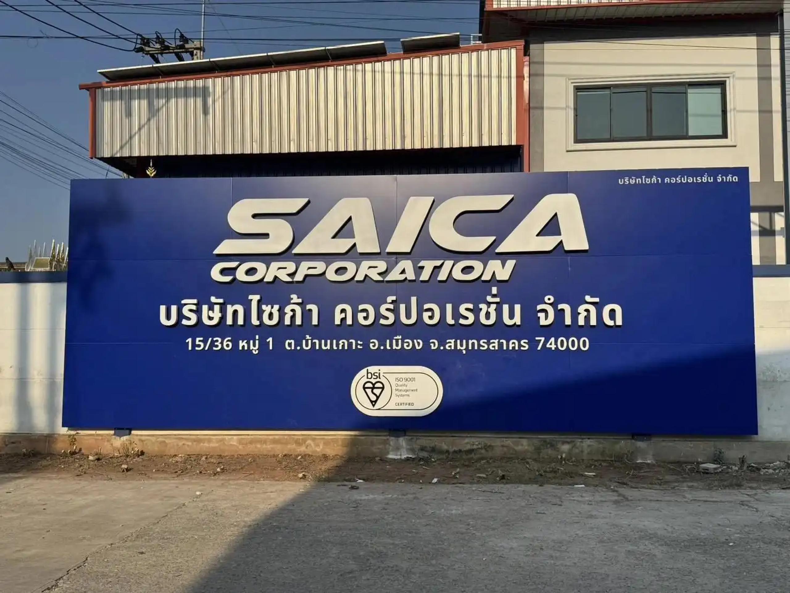 ป้ายชื่อบริษัท SAICA Corporation พร้อมที่อยู่และตราสัญลักษณ์รับรองมาตรฐาน ติดหน้าโรงงาน