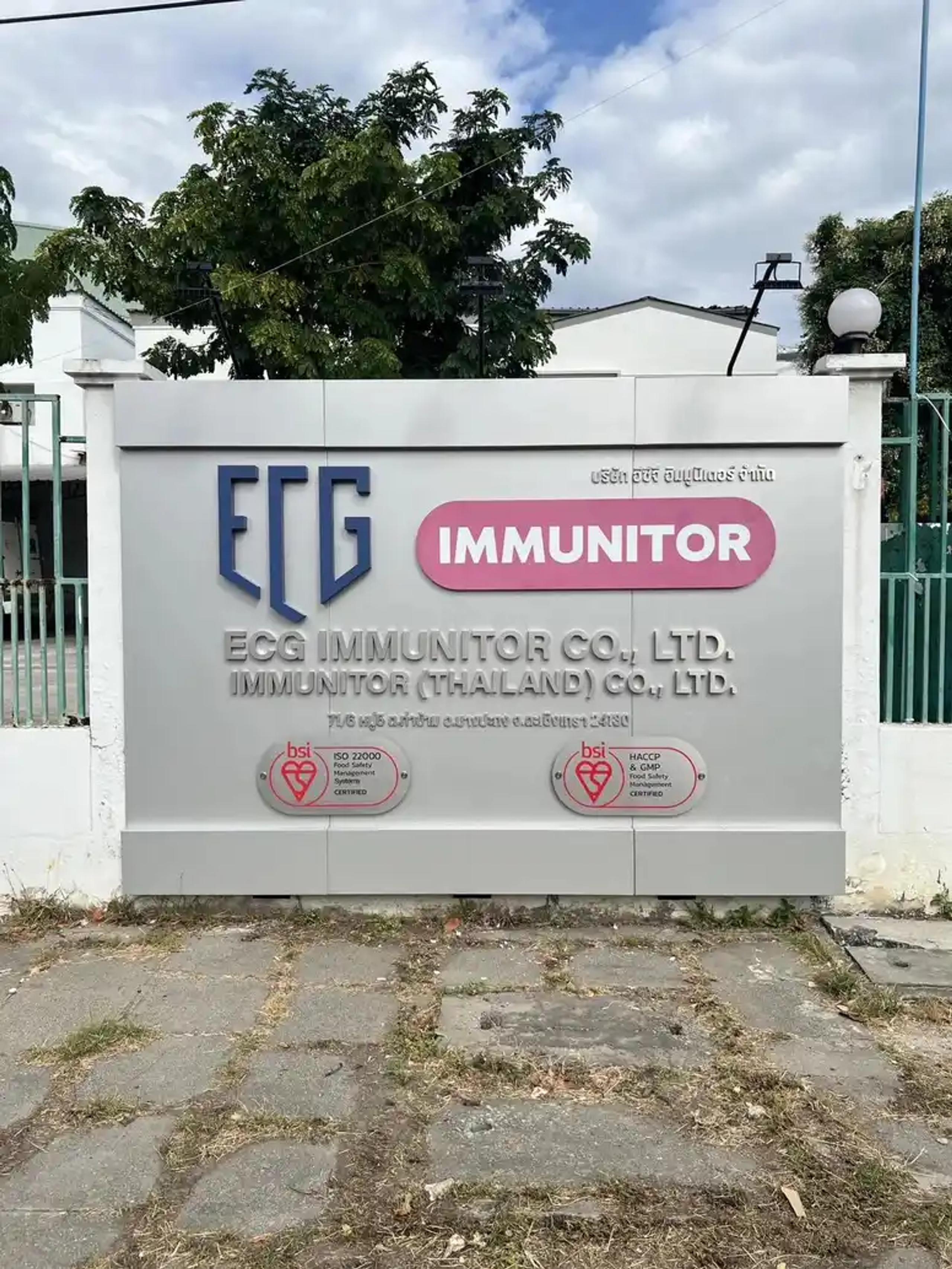ป้ายชื่อบริษัท ECG Immunitor Co., Ltd. พร้อมตราสัญลักษณ์รับรองมาตรฐานติดผนังกำแพง