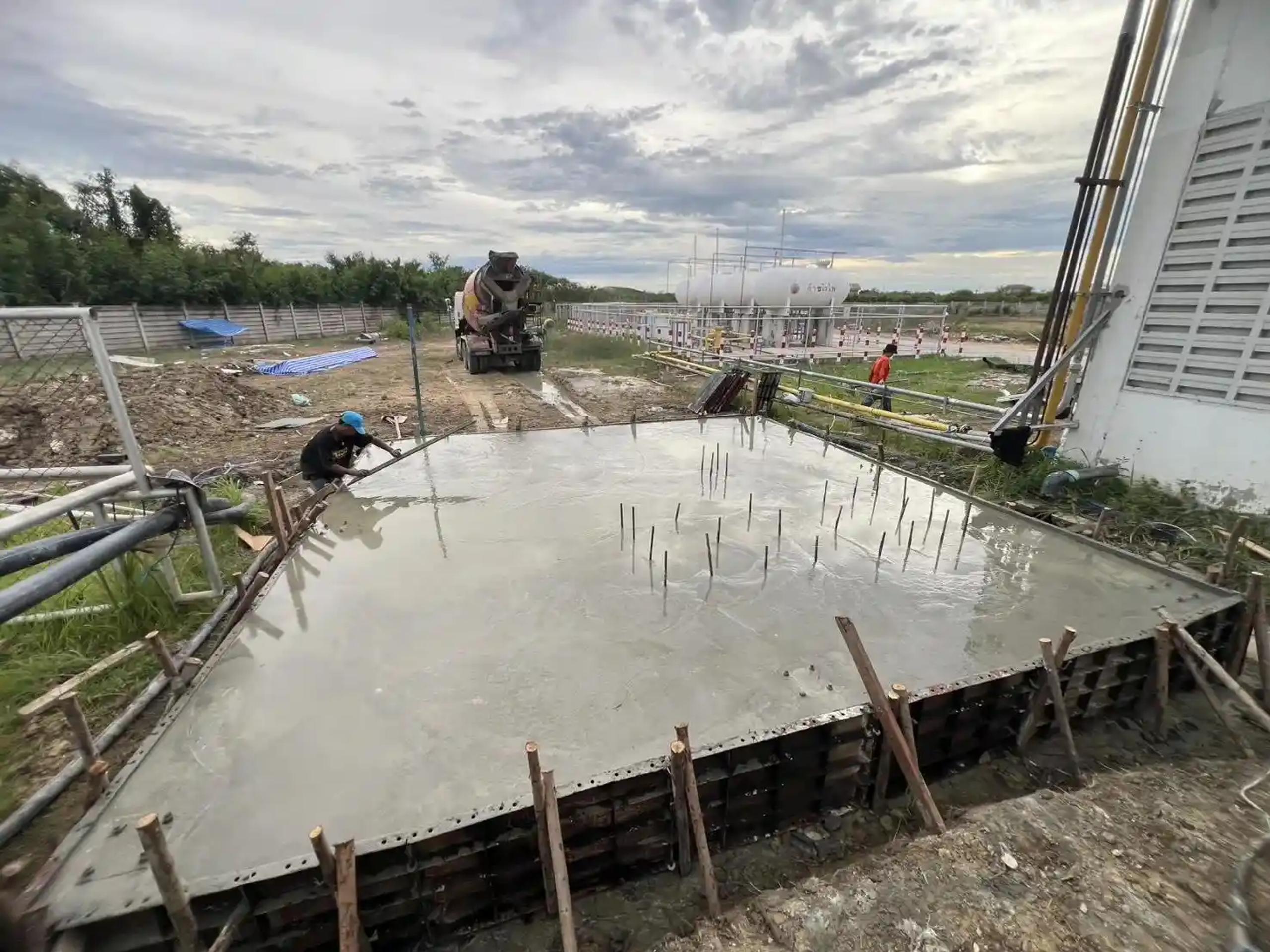 งานเทคอนกรีตฐานรากพร้อมเหล็กเสริมและรถโม่ปูนที่หน้างานโรงงาน | Concrete foundation pour with rebar and a concrete mixer truck at a factory site