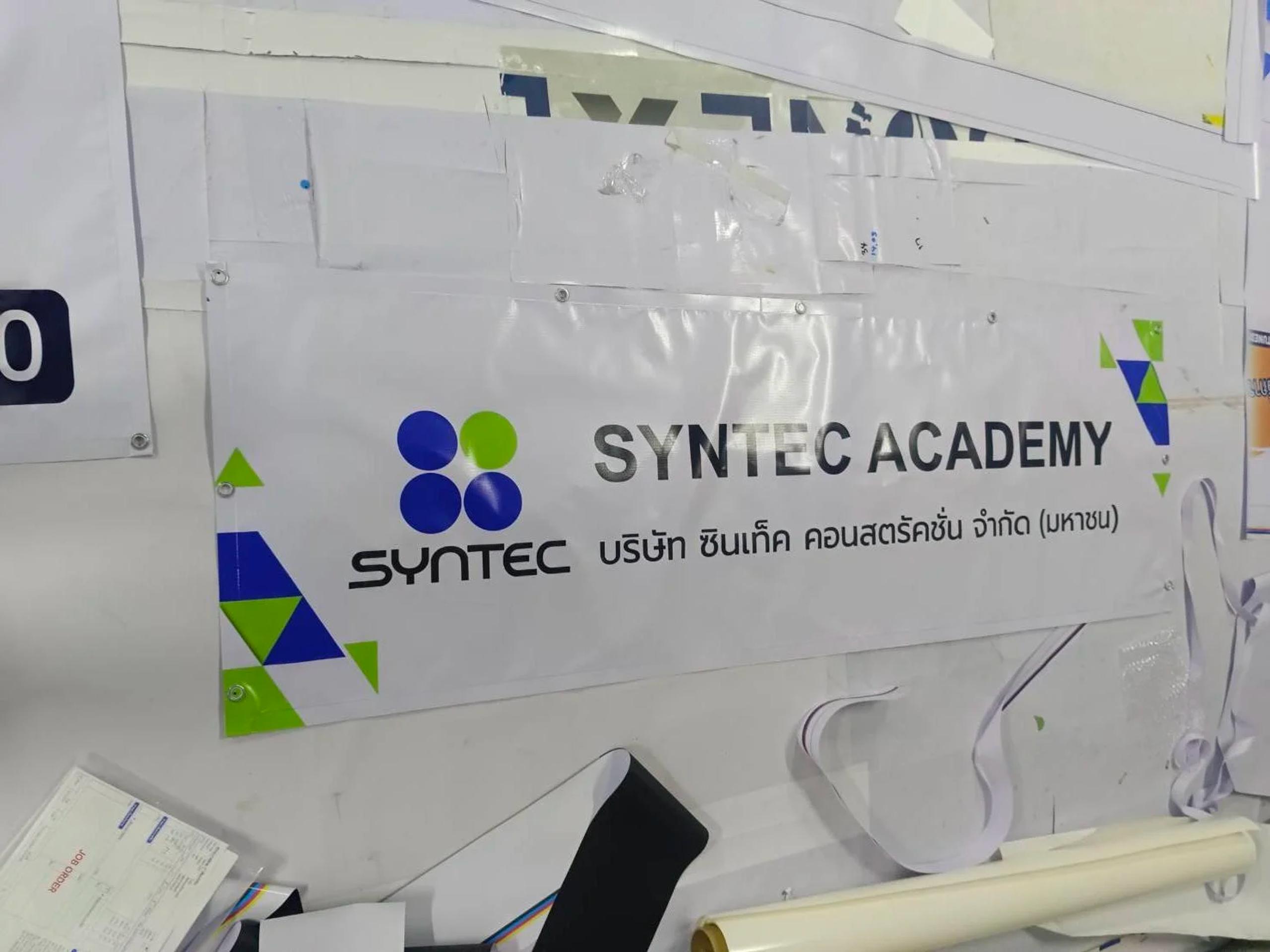 ป้ายไวนิล SYNTEC ACADEMY พร้อมโลโก้บริษัท ซินเท็ค คอนสตรัคชั่น | SYNTEC ACADEMY vinyl banner with the Syntec Construction company logo