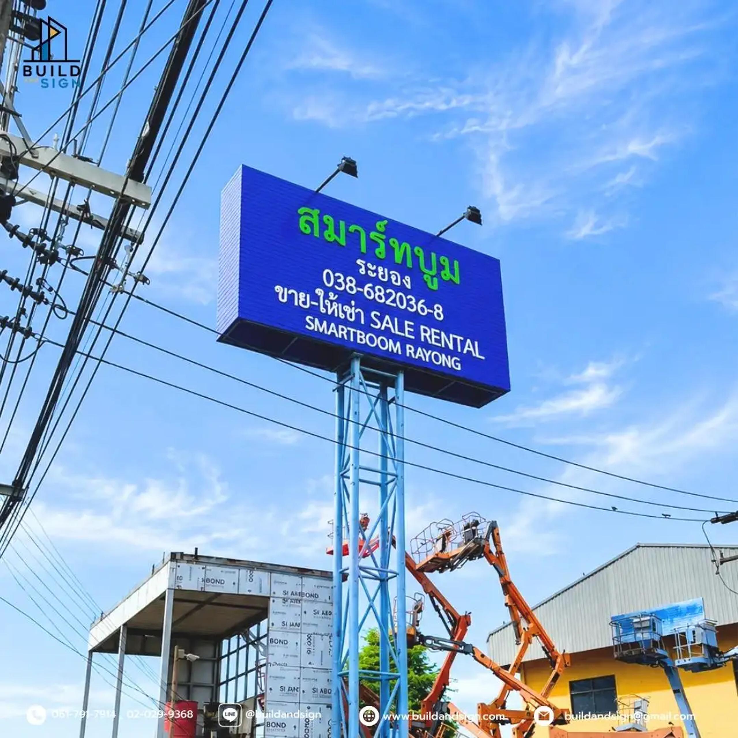 Tall pylon sign displaying a project name and contact details