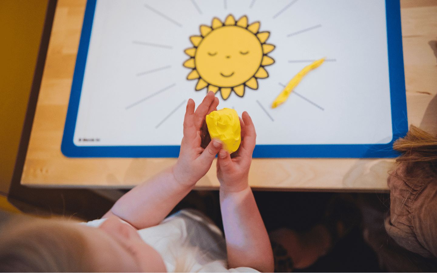 kind in kunstlokaal maakt zon van klei