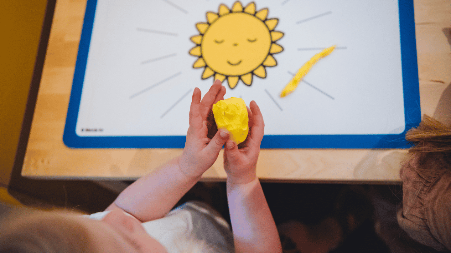 kind in kunstlokaal maakt zon van klei