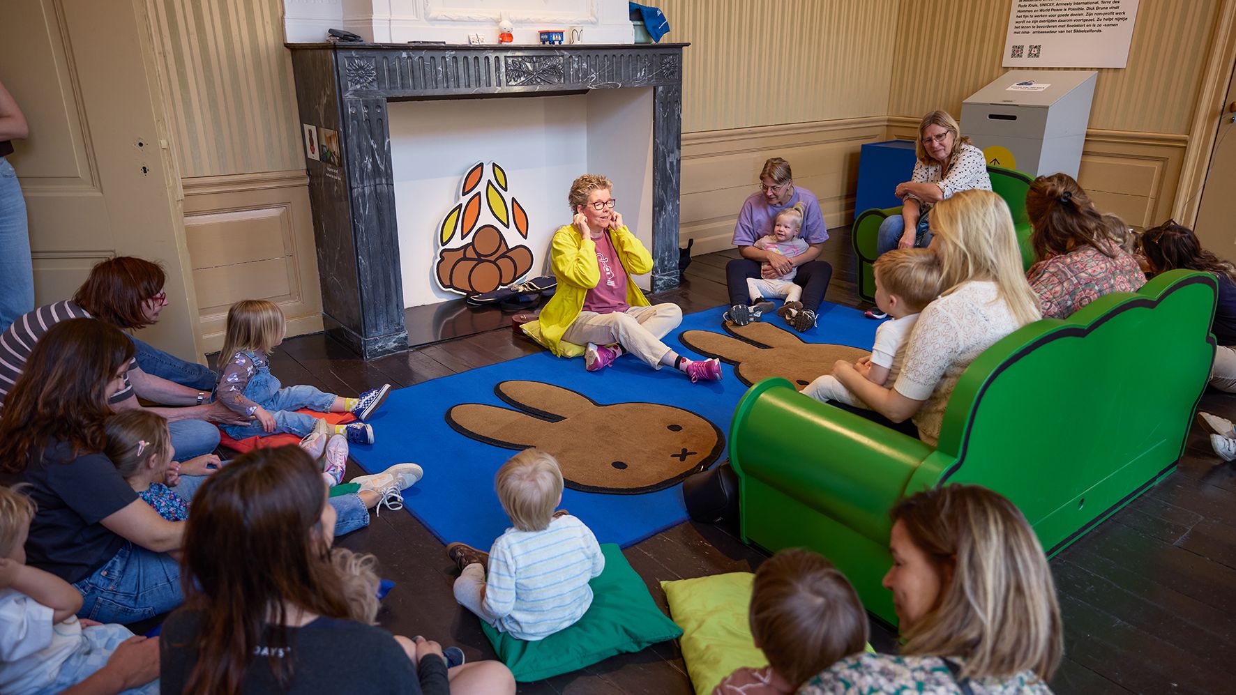 kinderen en begeleiders zitten in kring bij muziekworkshop