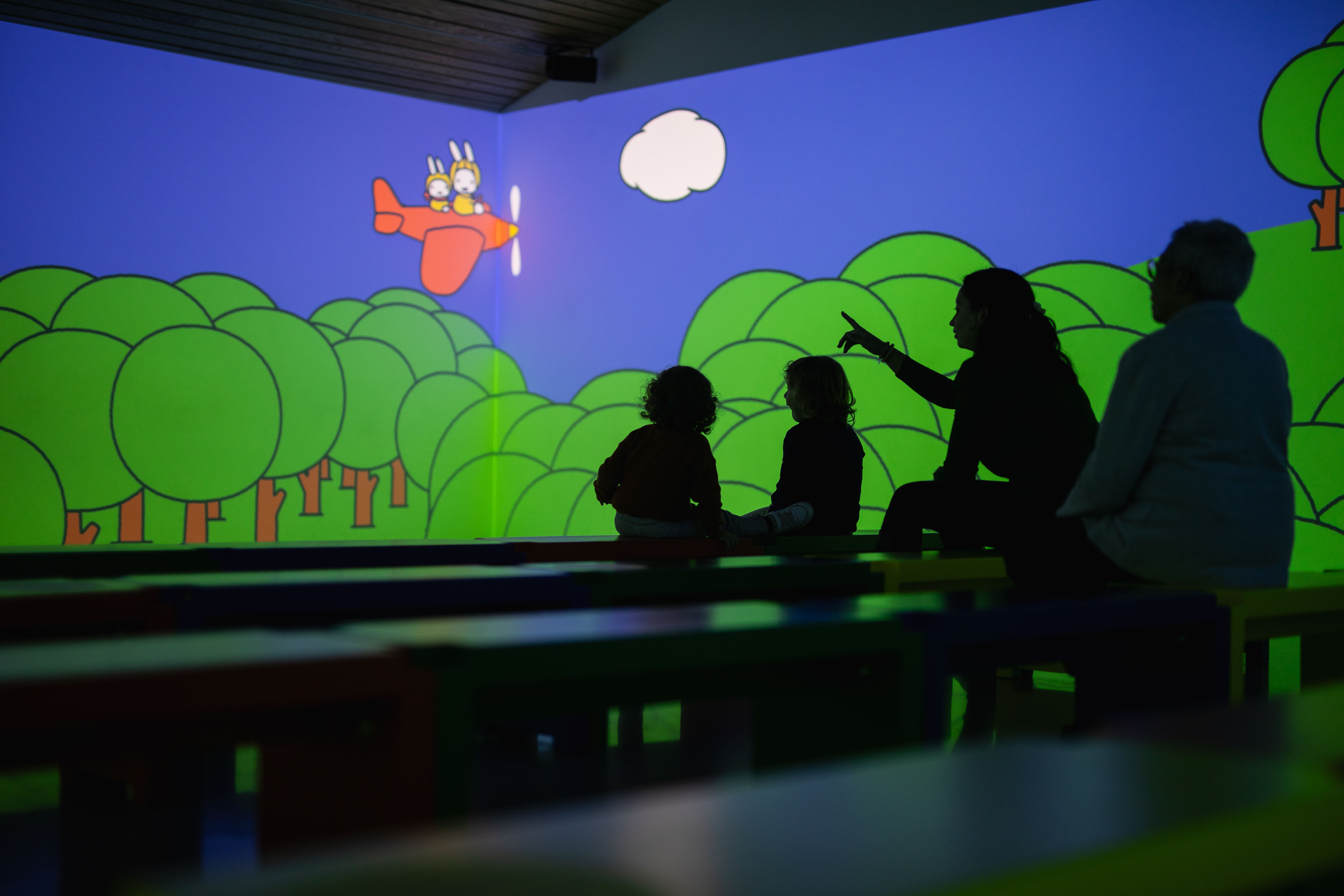 Children and adults looking at projection