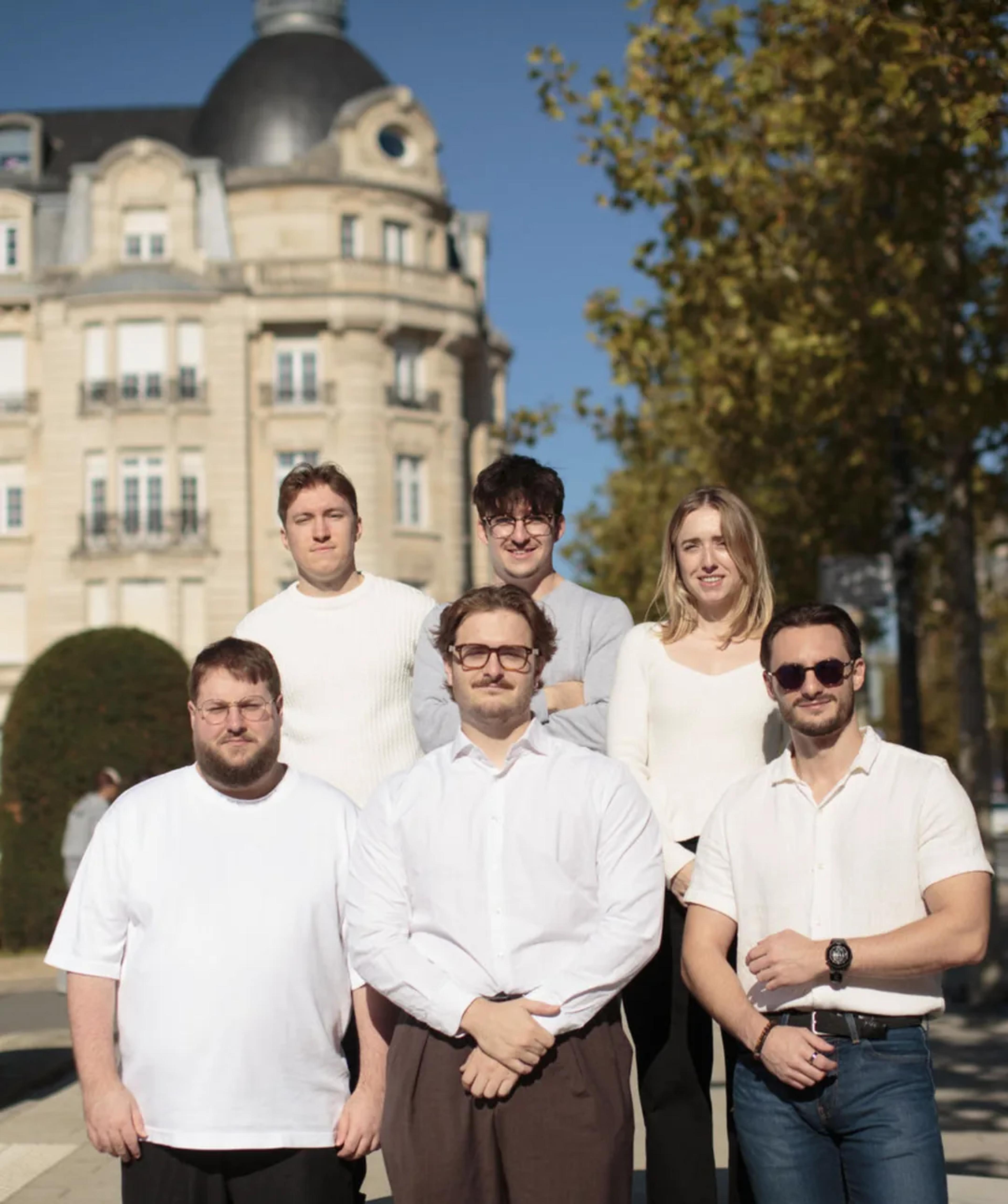 The Hash Consulting team standing together on a sunny street in front of a Haussmann-style building.