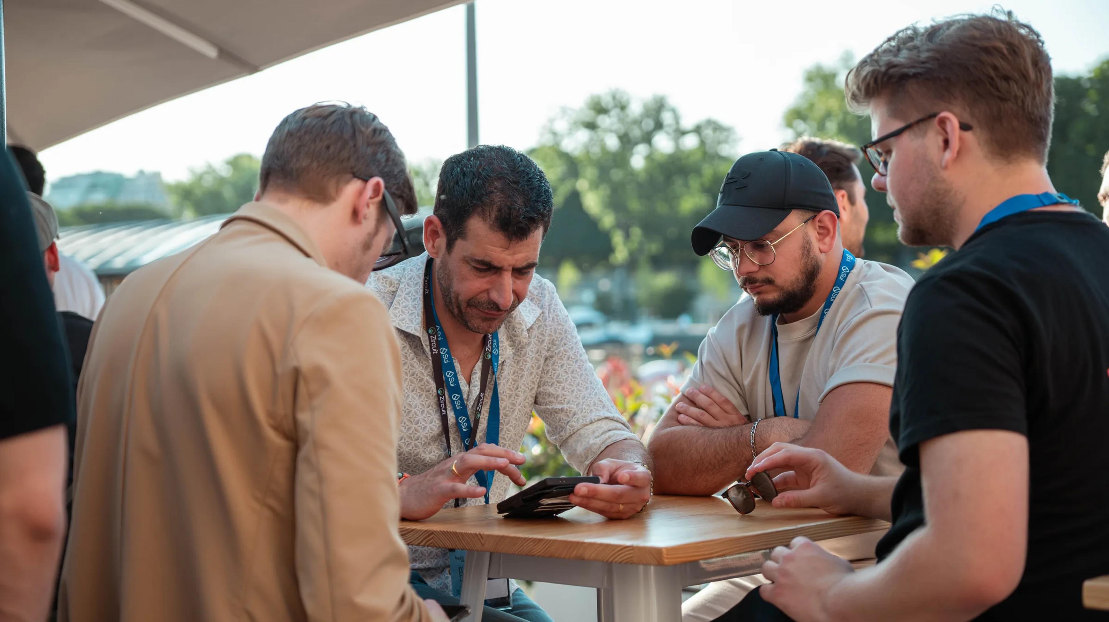 Attendees talking around a table on the terrace