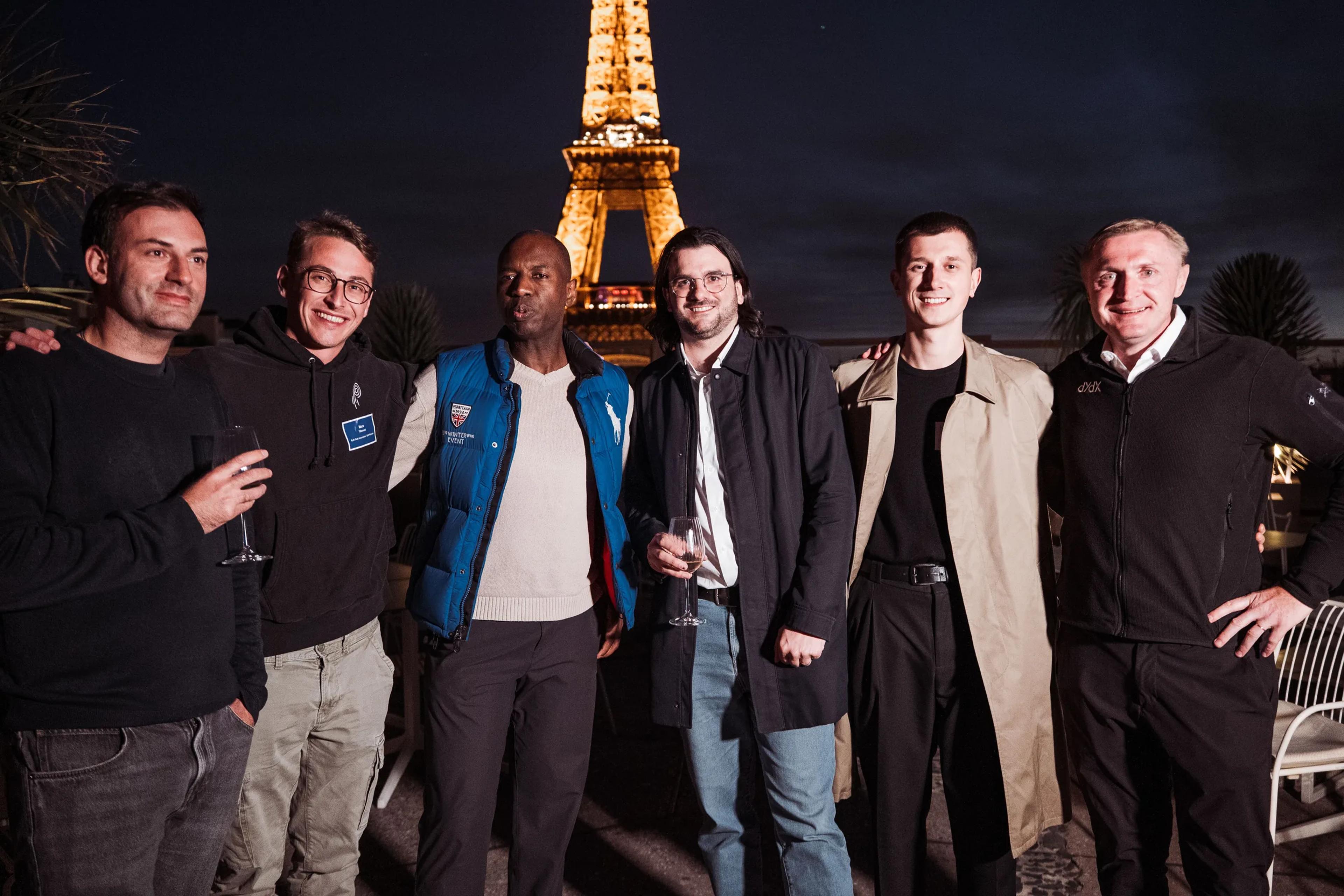 The dYdX team at night in front of the illuminated Eiffel Tower during Paris Blockchain Week