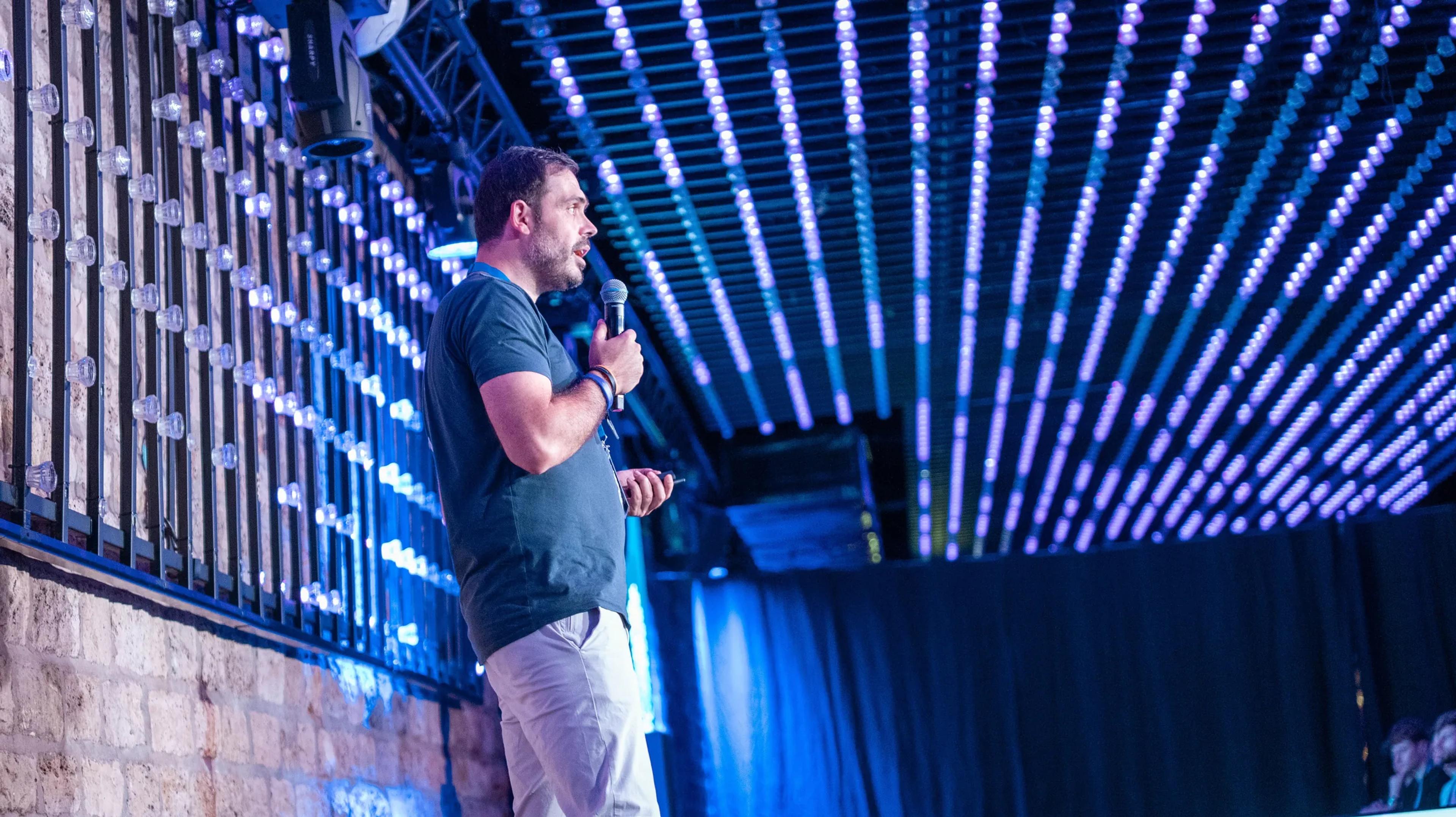 A speaker presenting under the venue's LED light grid at Sui Connect Paris