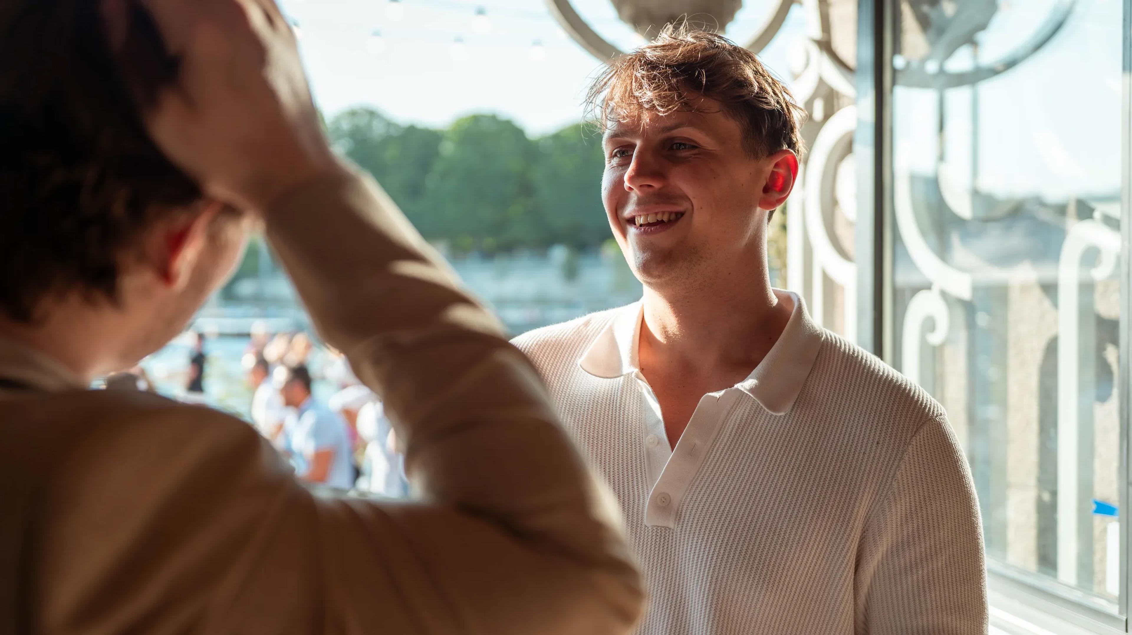 Guests chatting by a window overlooking the Seine