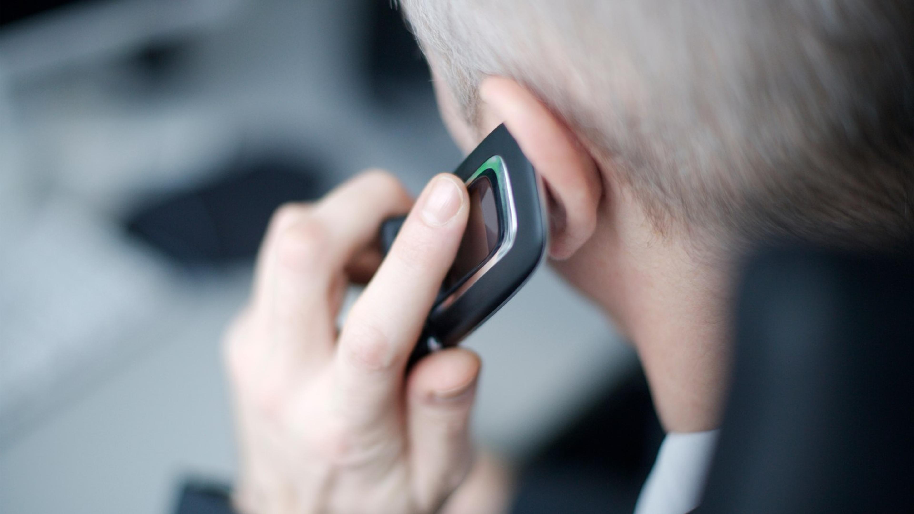 Professional using a cell phone at the workplace — HubSpot click-to-call and sales softphone