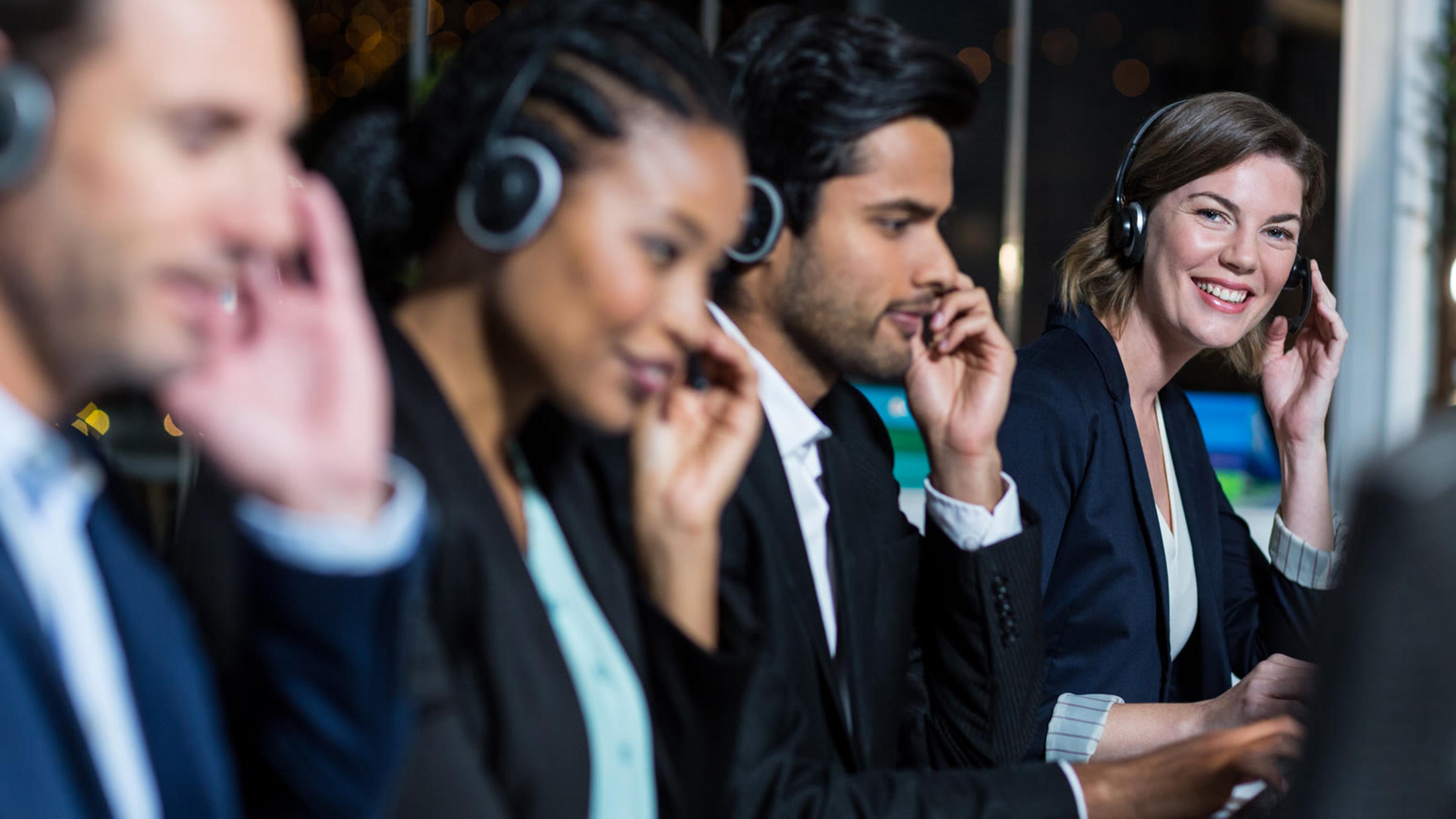 Customer service team working with headsets in a modern office